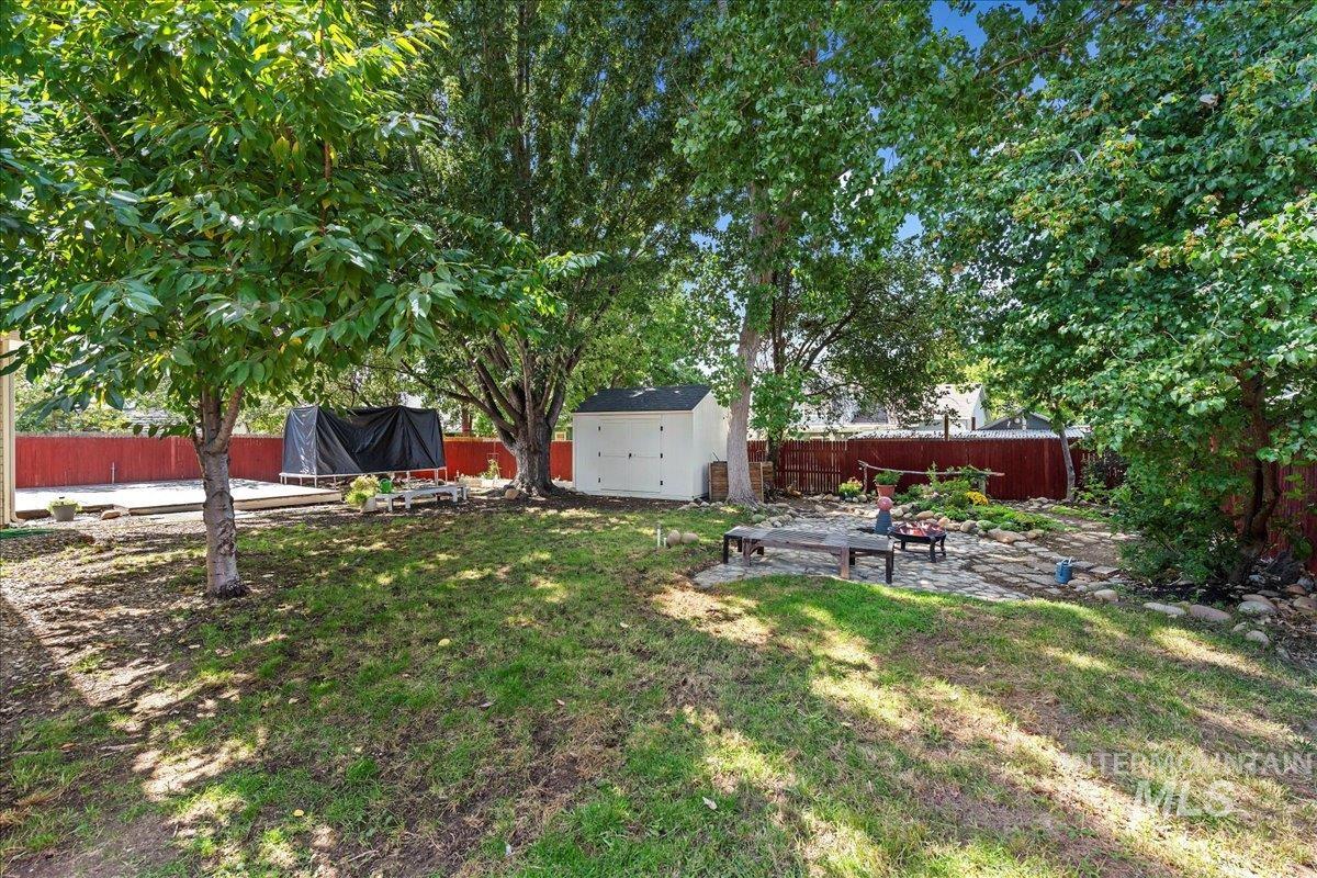 Fenced backyard featuring a patio and a storage shed