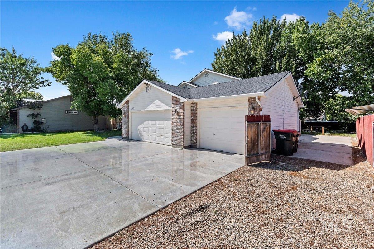 View of front of house featuring concrete driveway, an attached garage, brick siding, and a front yard