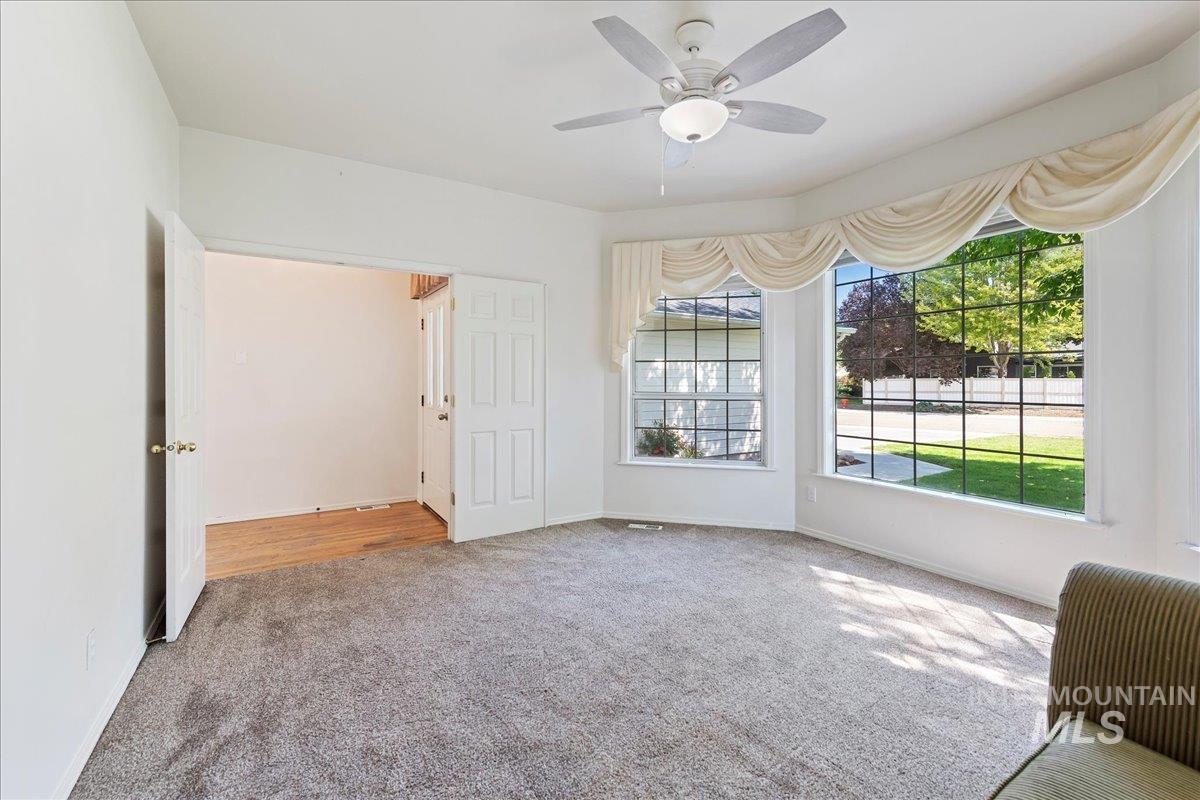 Unfurnished room featuring carpet flooring, healthy amount of natural light, and ceiling fan