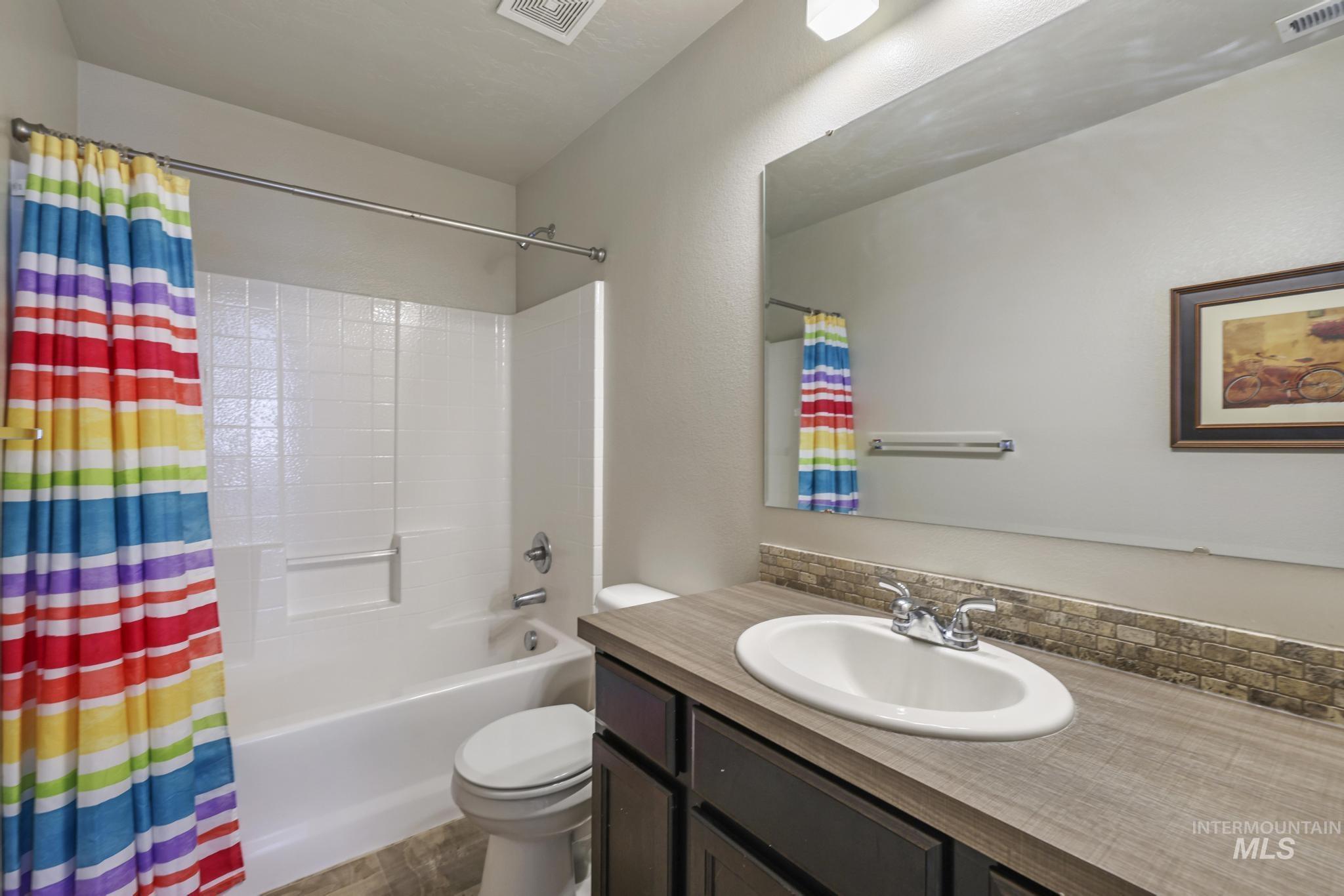 Bathroom with shower / bathtub combination with curtain and vanity