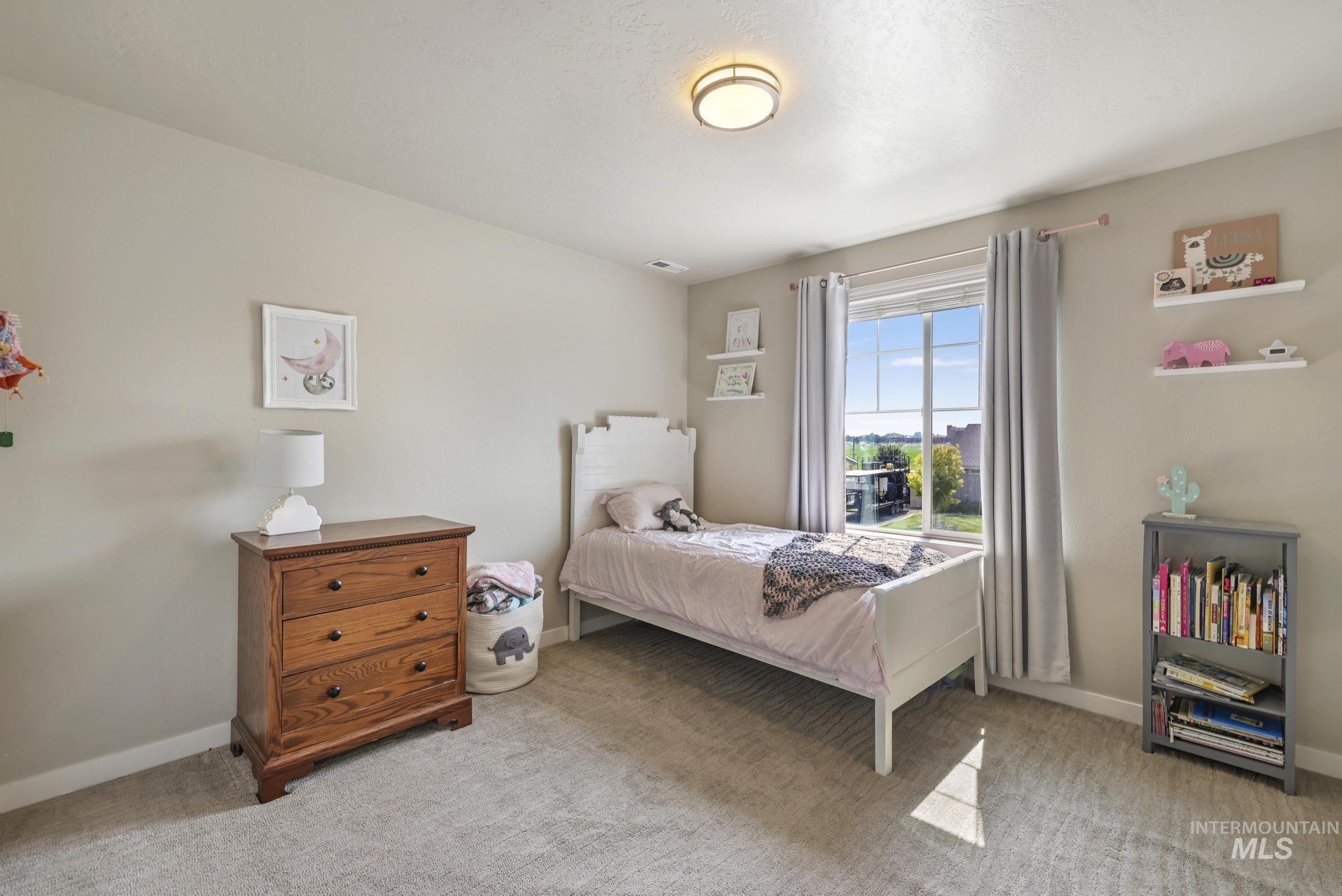 Bedroom with light carpet and baseboards