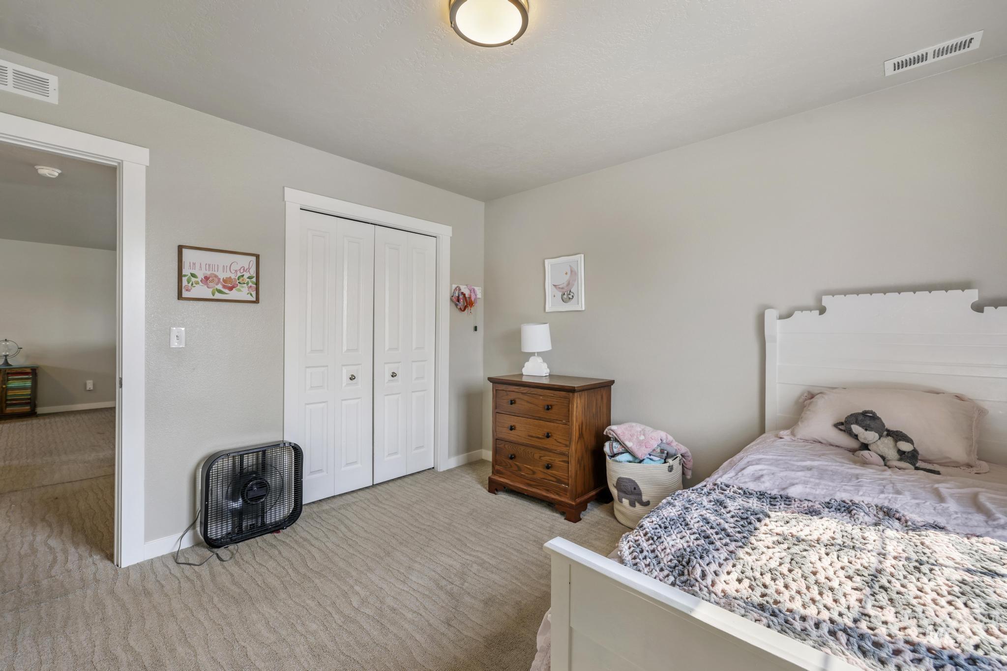 Bedroom with light carpet and a closet
