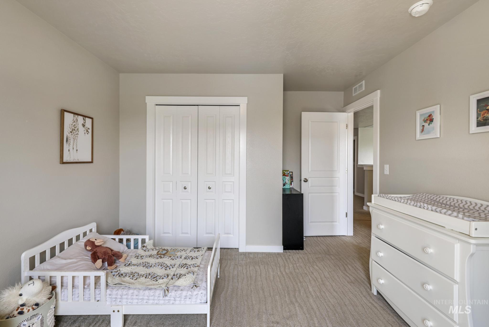 Bedroom featuring light carpet and a closet