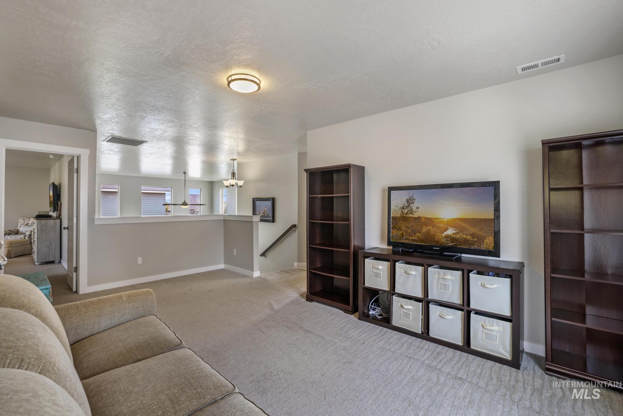 Living room featuring carpet and a textured ceiling