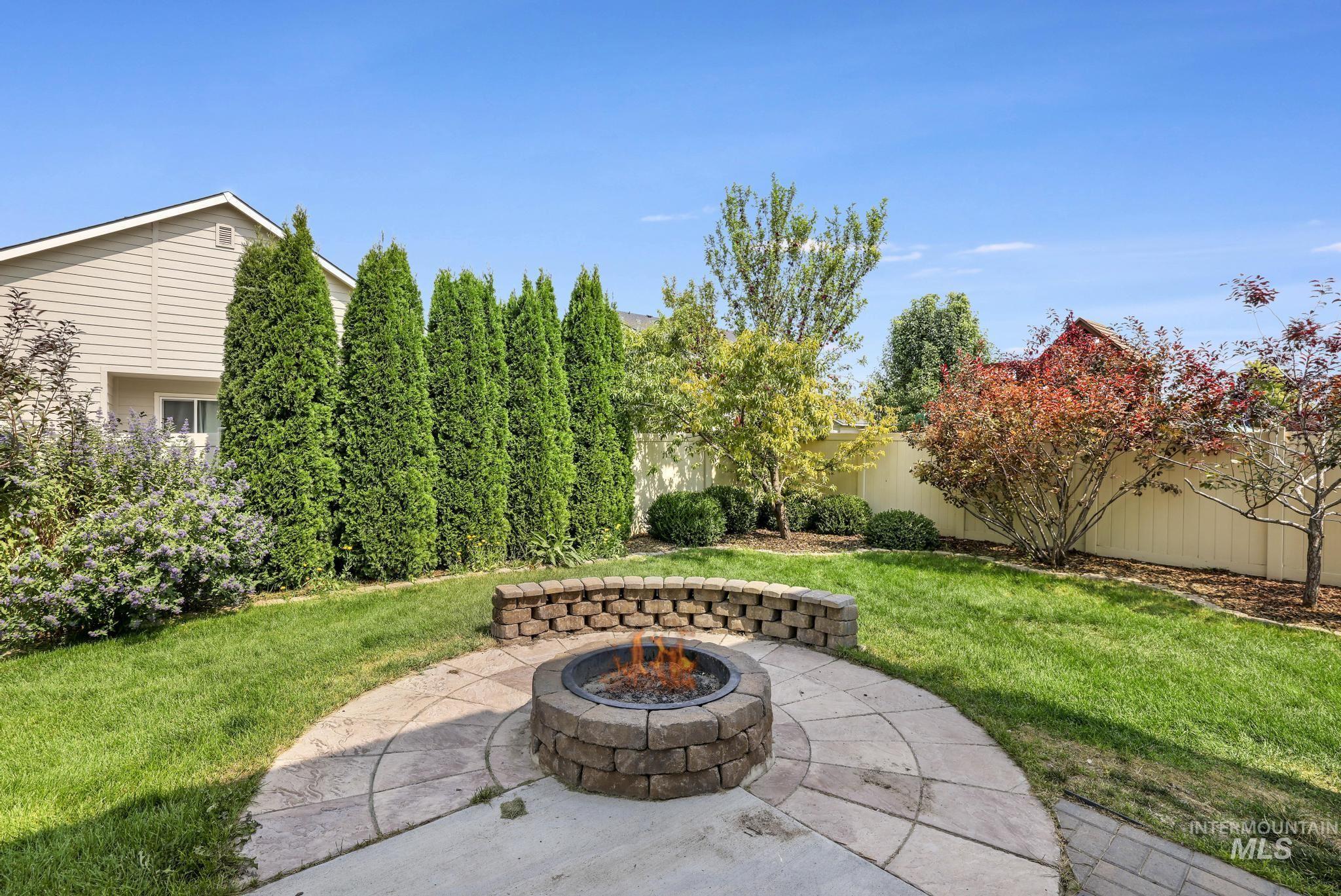 Fenced backyard featuring a patio area and a fire pit