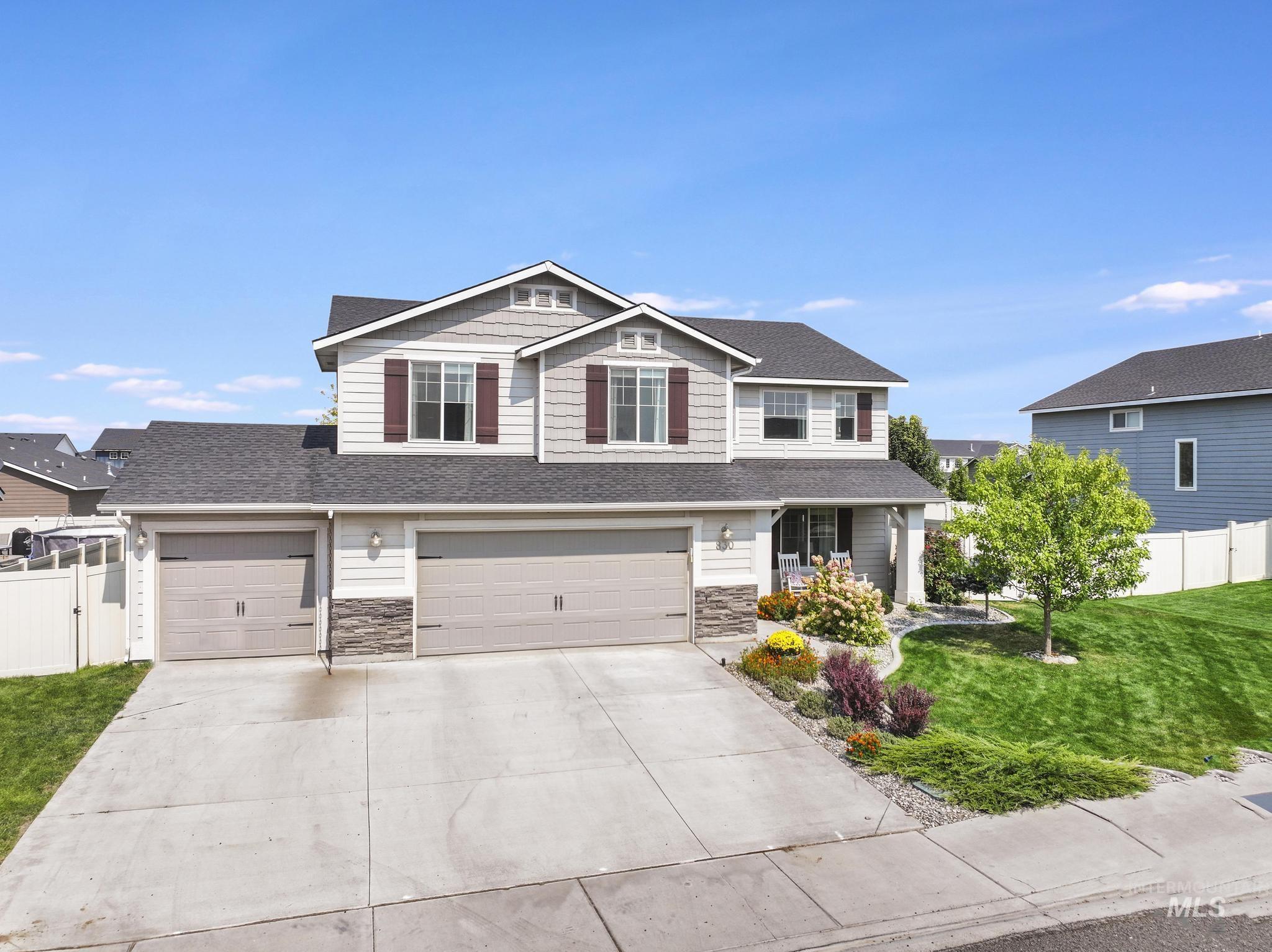 Craftsman-style house featuring concrete driveway, a shingled roof, stone siding, and an attached garage