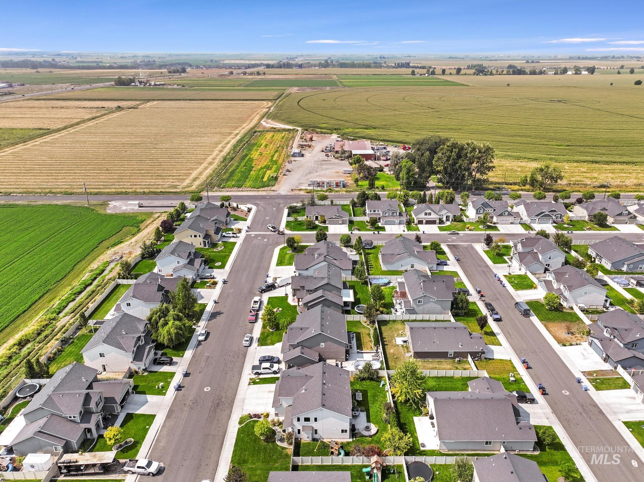 Aerial view of property and surrounding area with nearby suburban area and rural landscape