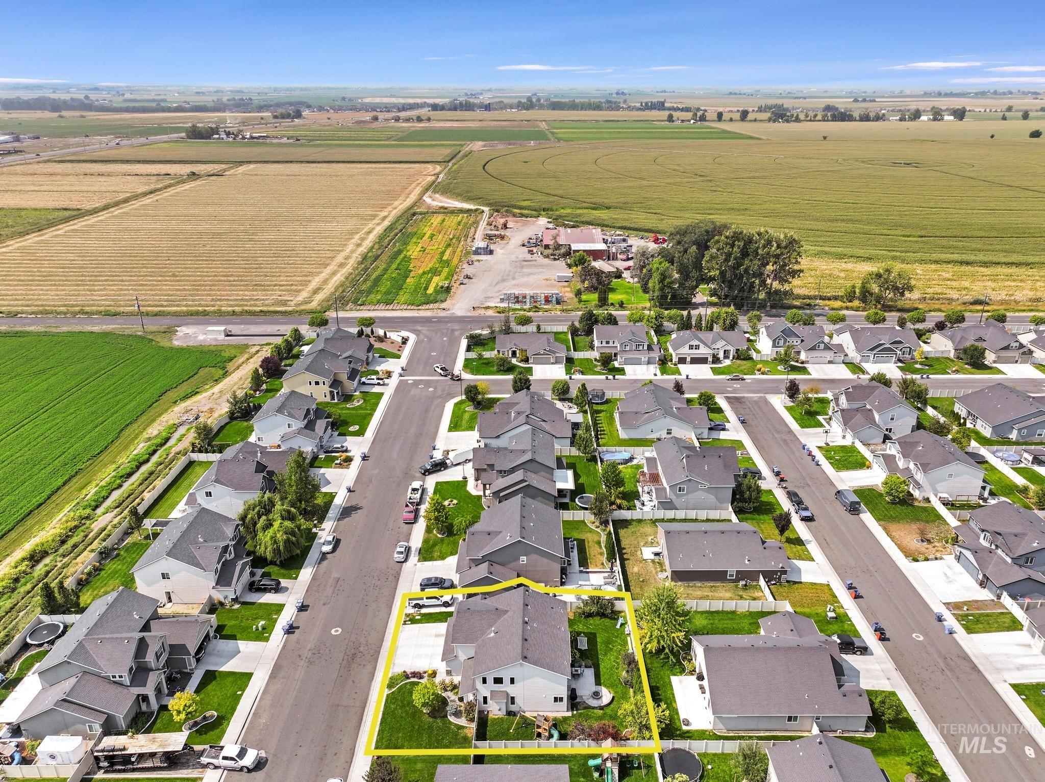 Aerial view of property's location featuring nearby suburban area, property parcel outlined, and rural landscape
