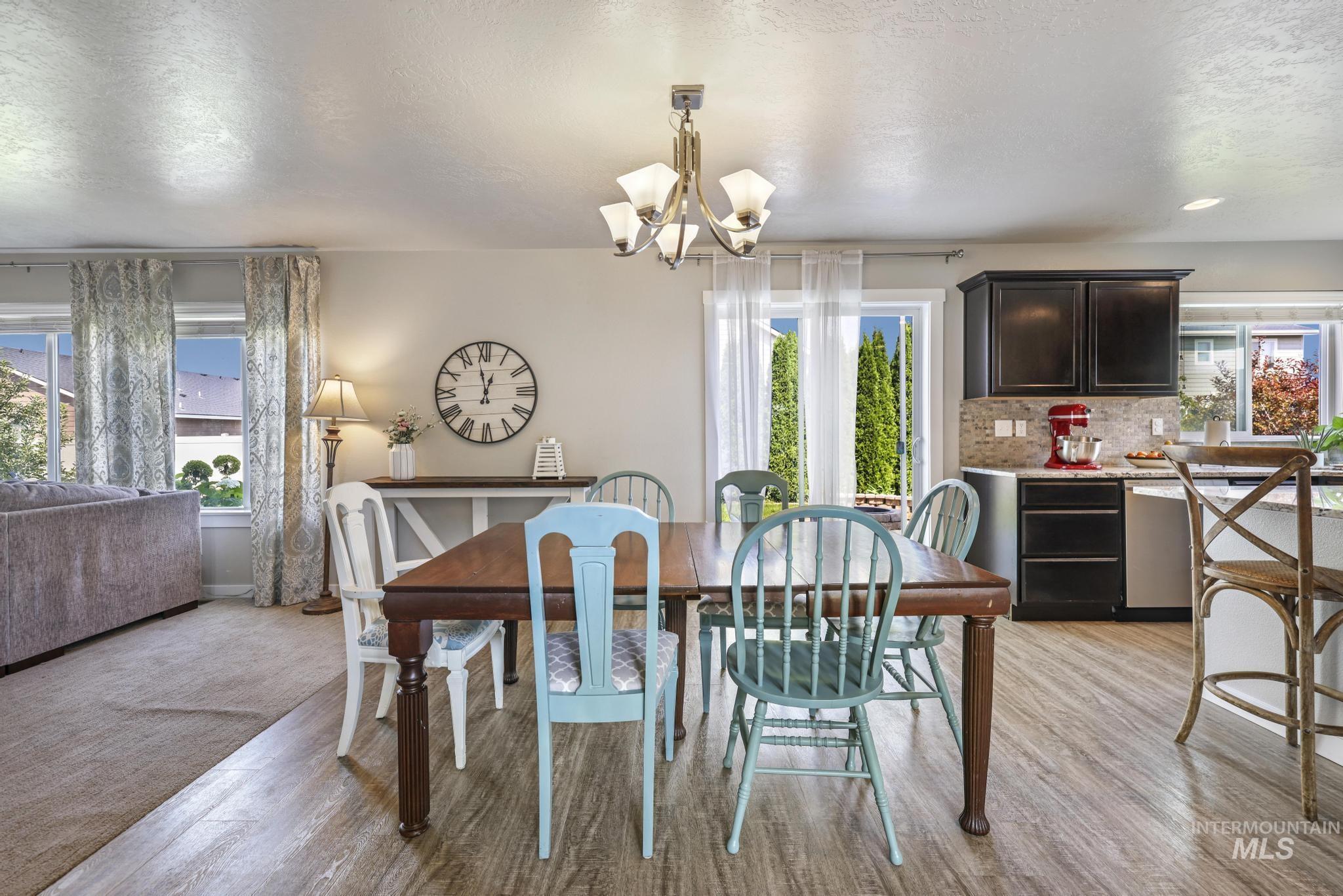 Dining room featuring a textured ceiling, light wood finished floors, and a chandelier