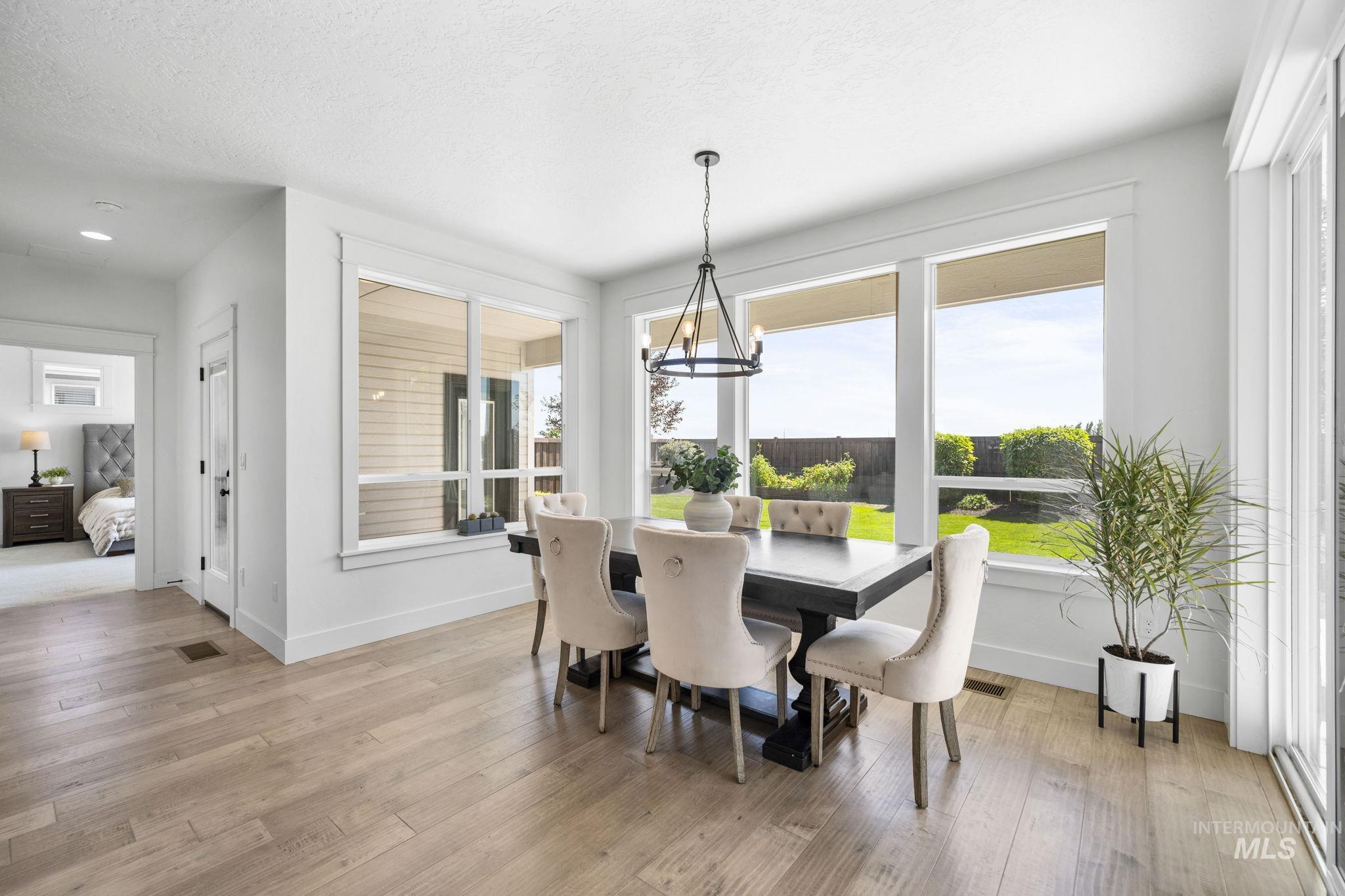 Dining space with plenty of natural light, light wood-style flooring, and a textured ceiling