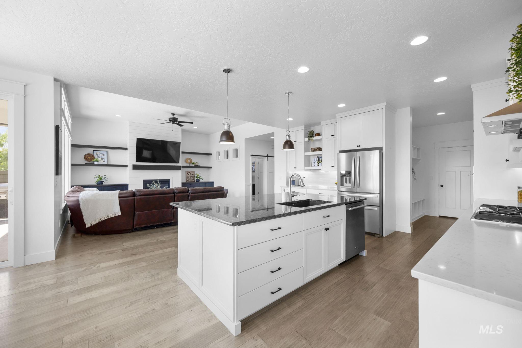Kitchen with open shelves, white cabinetry, dark stone counters, recessed lighting, and a textured ceiling