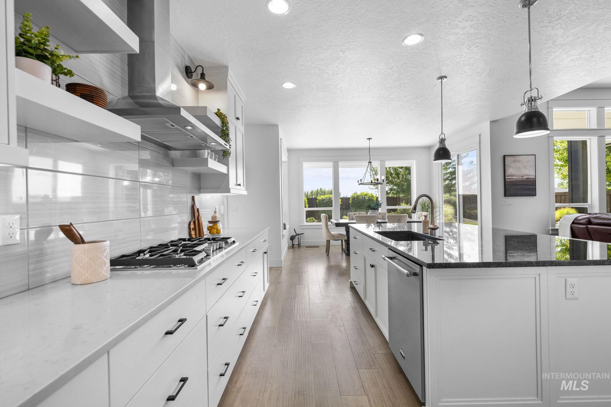 Kitchen with open shelves, dark stone countertops, white cabinets, a textured ceiling, and wall chimney range hood