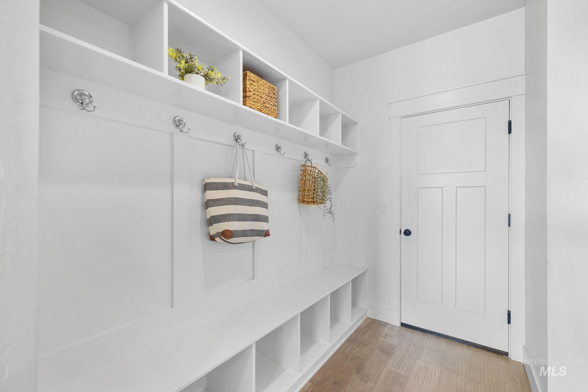 Mudroom featuring light wood-style flooring and baseboards