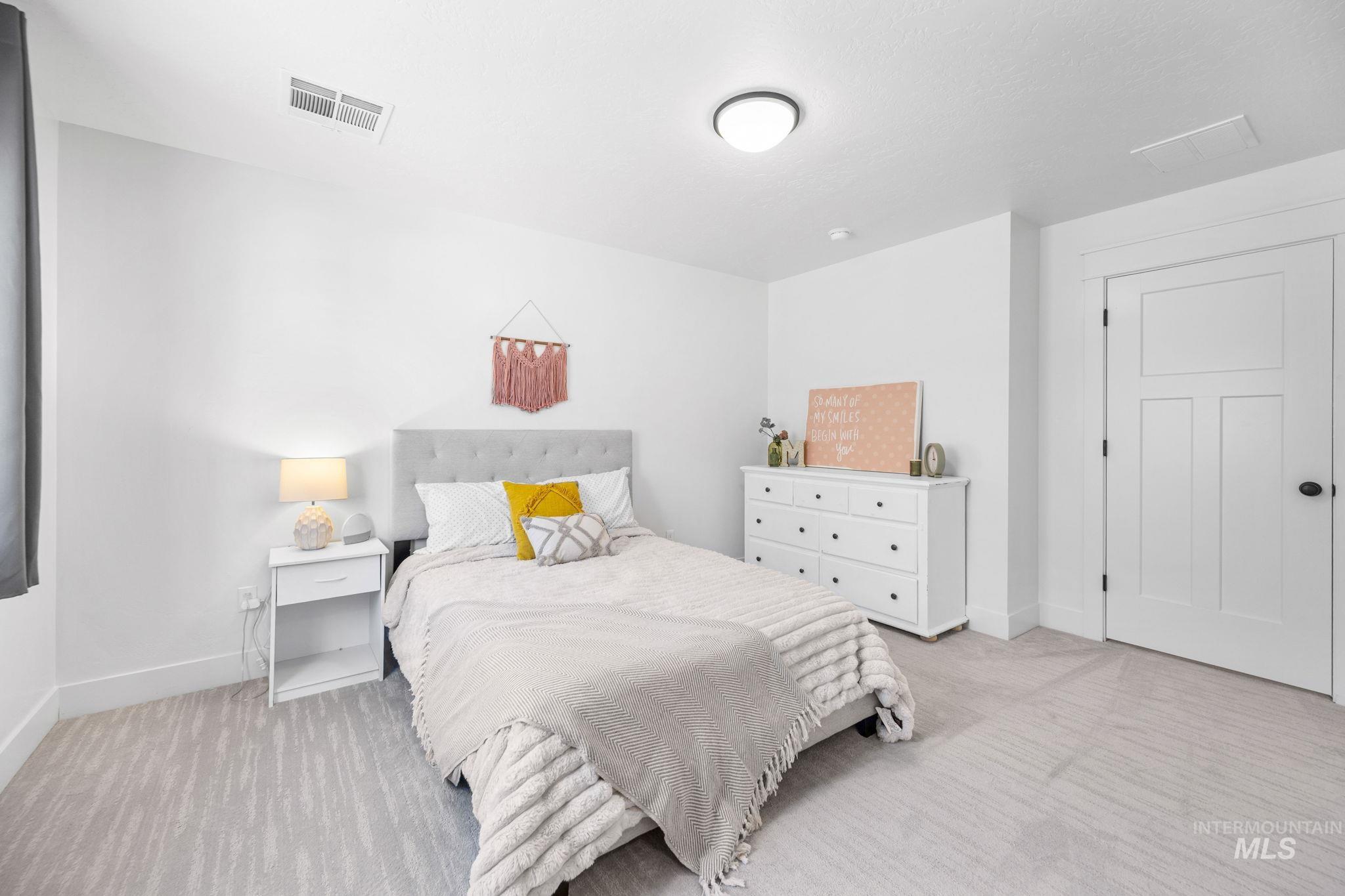 Second story bedroom with light colored carpet
