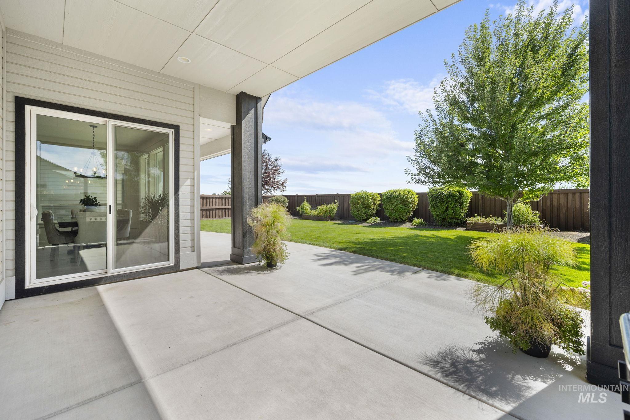 Fenced backyard with a covered patio area