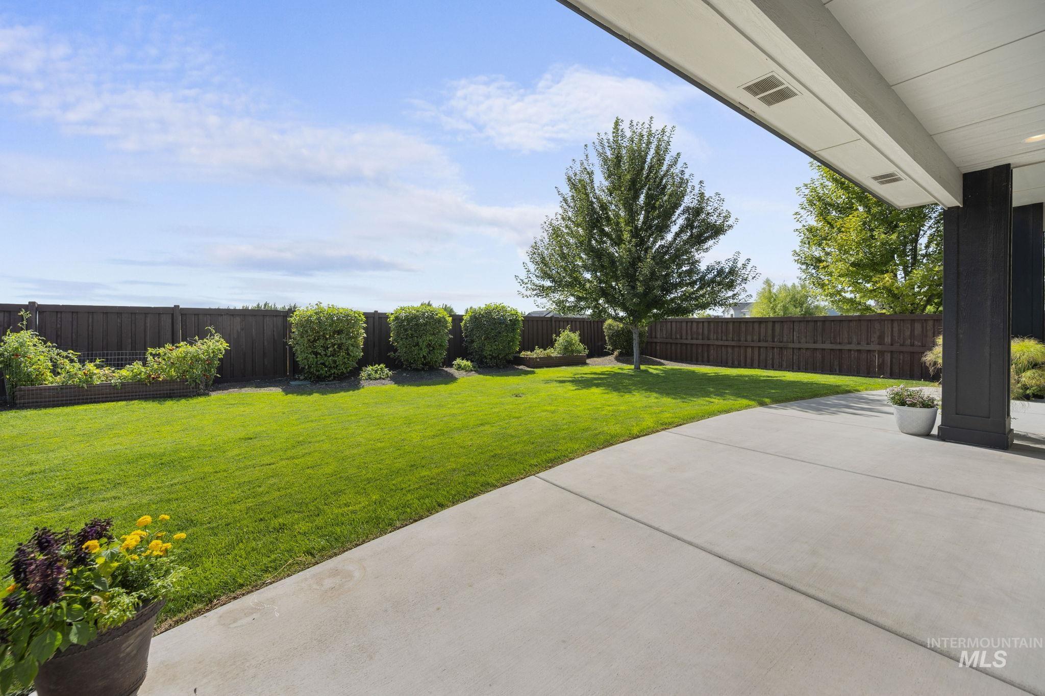 Spacious fenced backyard featuring a cover patio on corner lot.