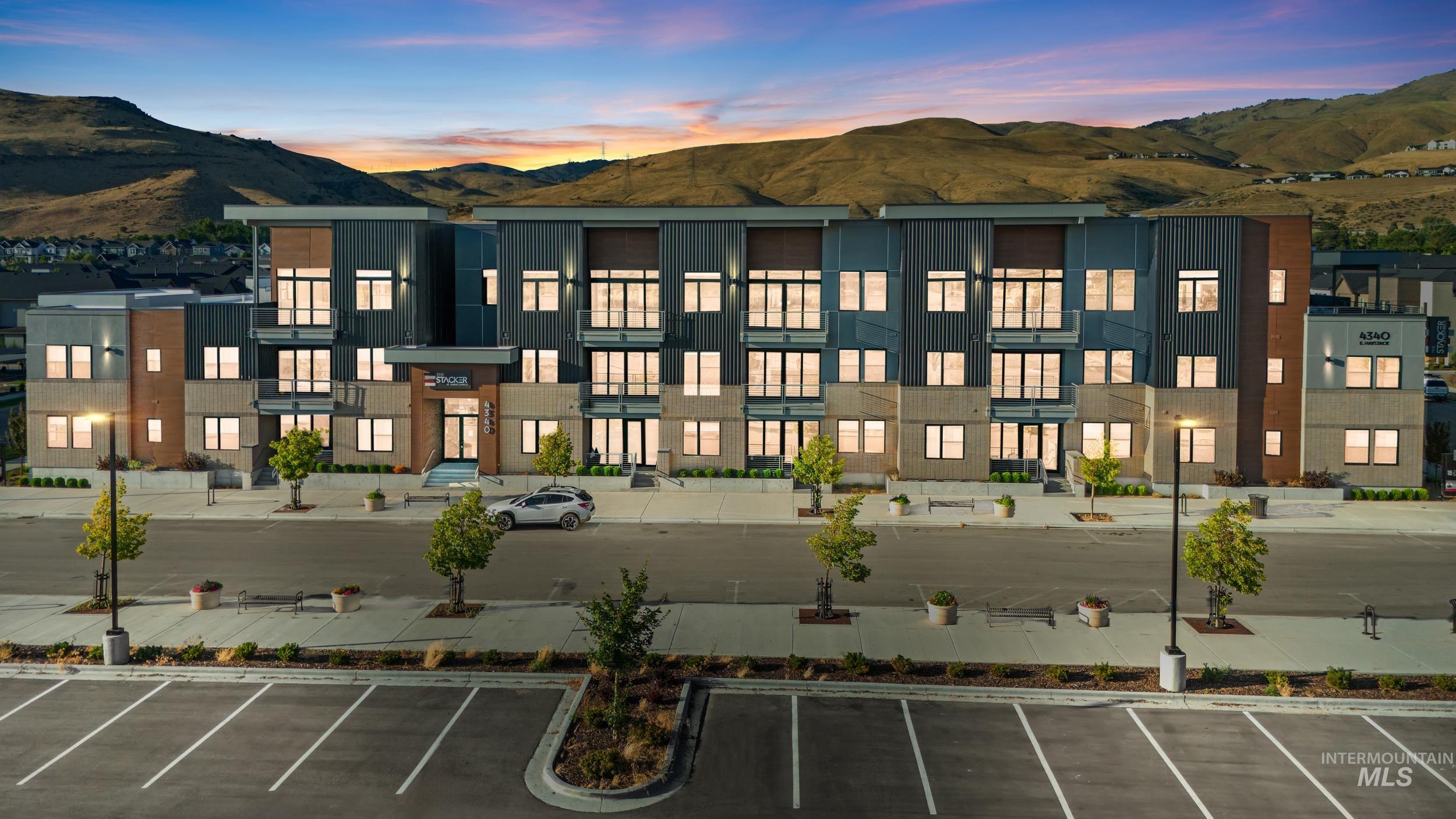 View of building exterior featuring a mountain view and uncovered parking