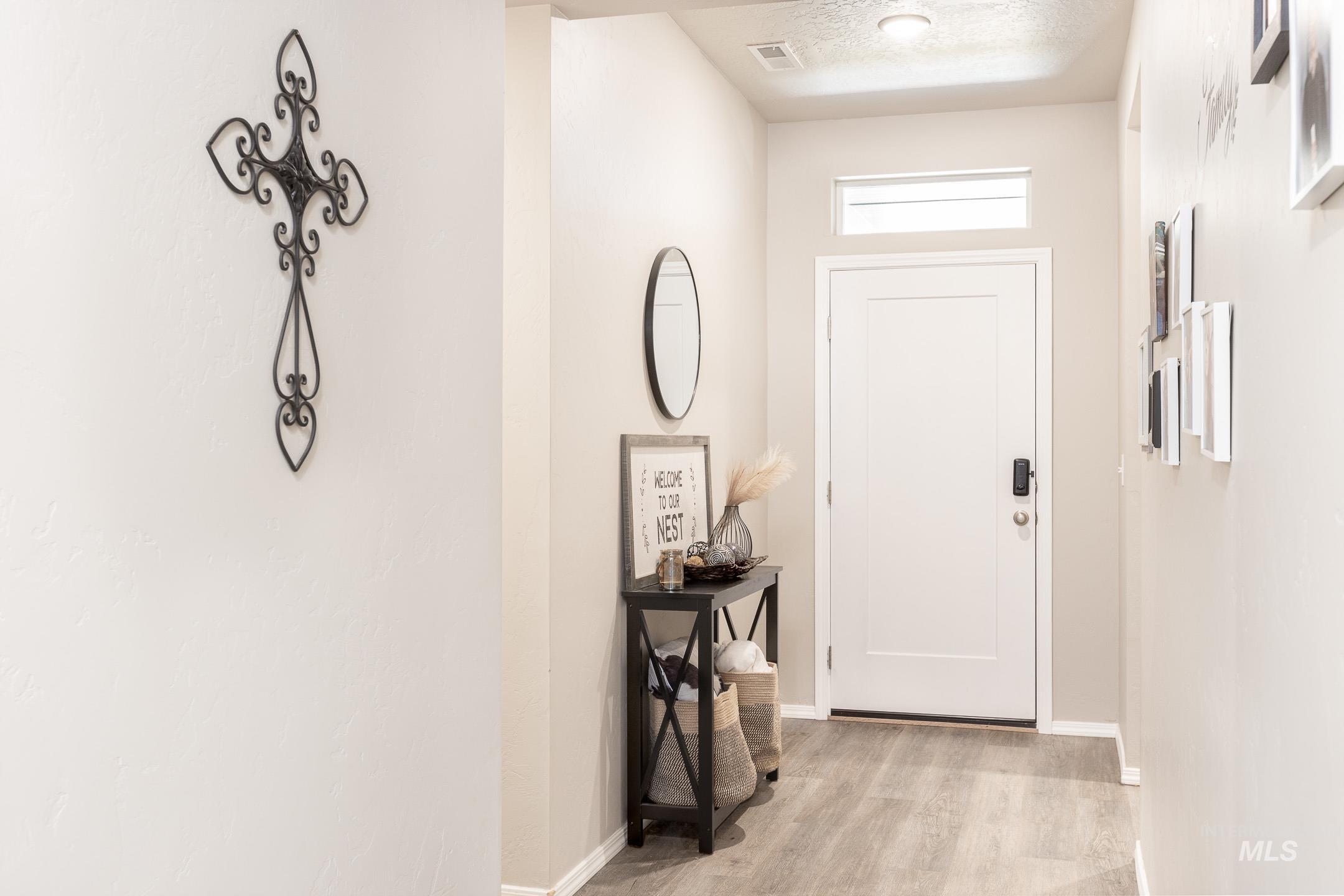 Doorway with wood finished floors and a textured ceiling