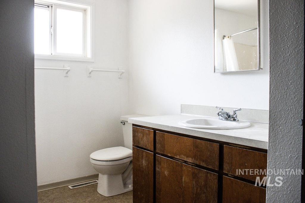 Full bathroom with vanity, dark tile patterned flooring, and curtained shower