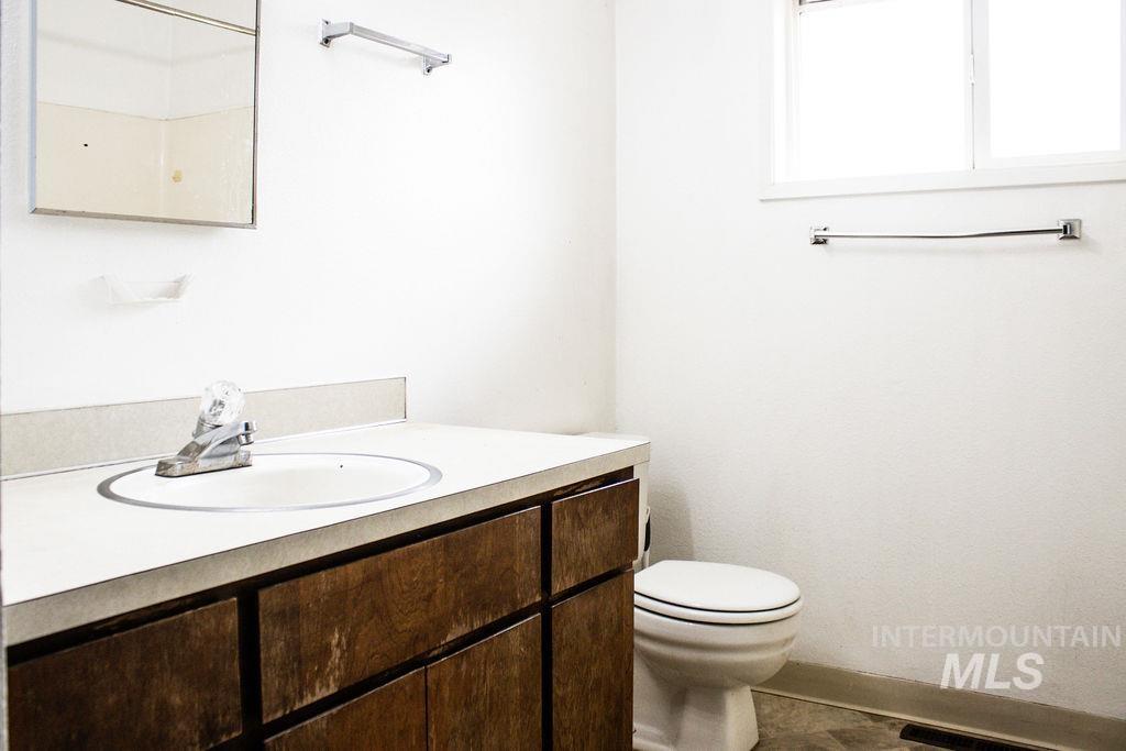 Half bathroom with vanity and toilet