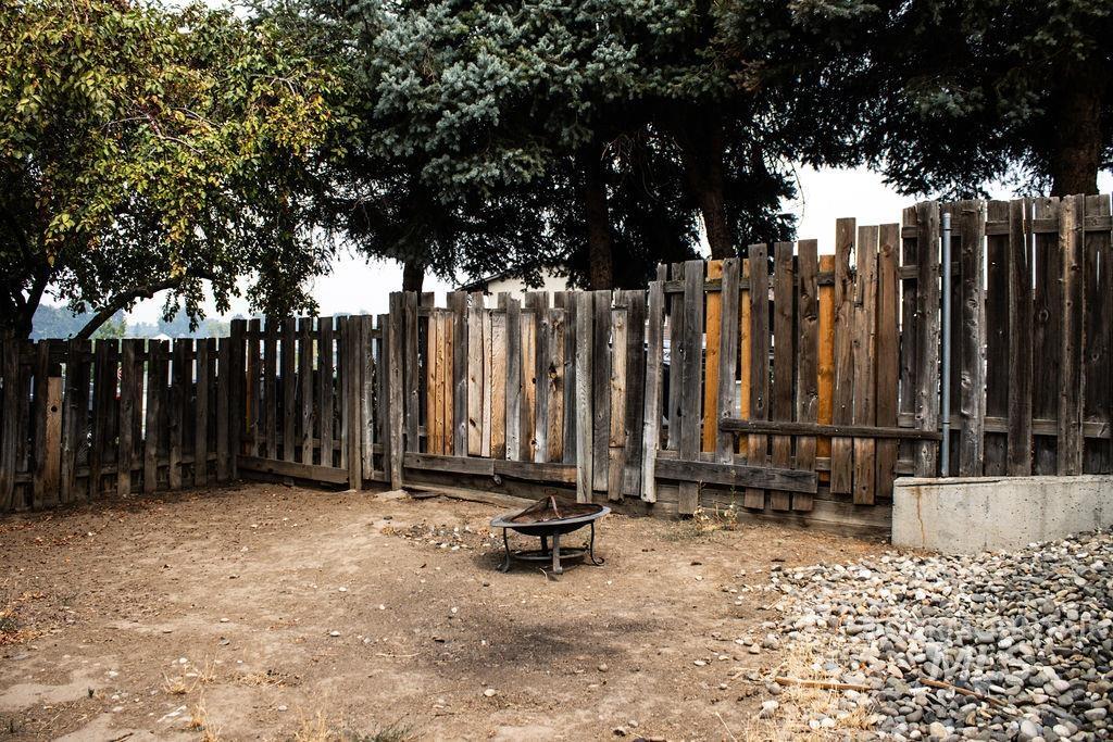 Fenced backyard with an outdoor fire pit