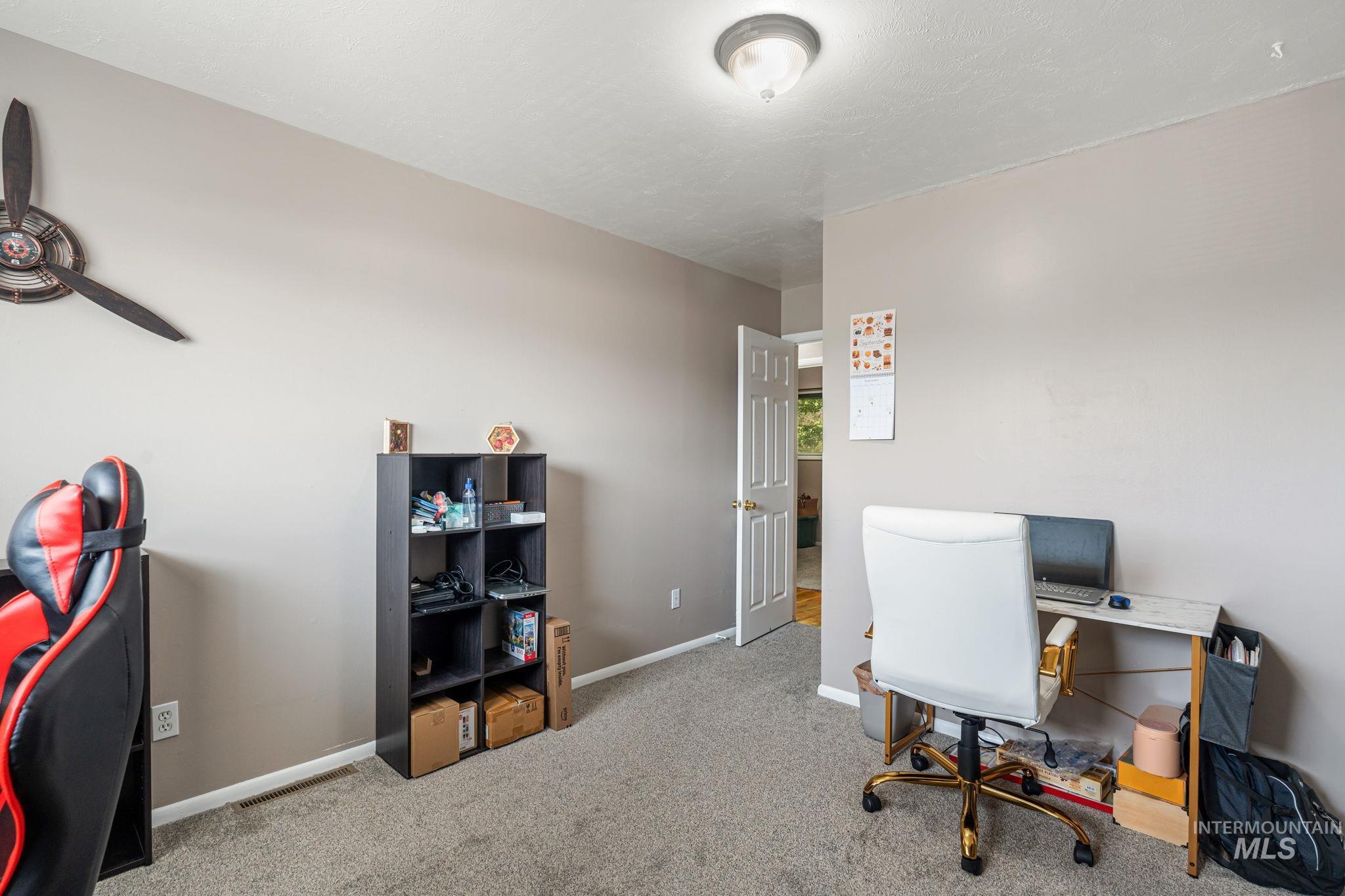 Office space with light colored carpet and baseboards