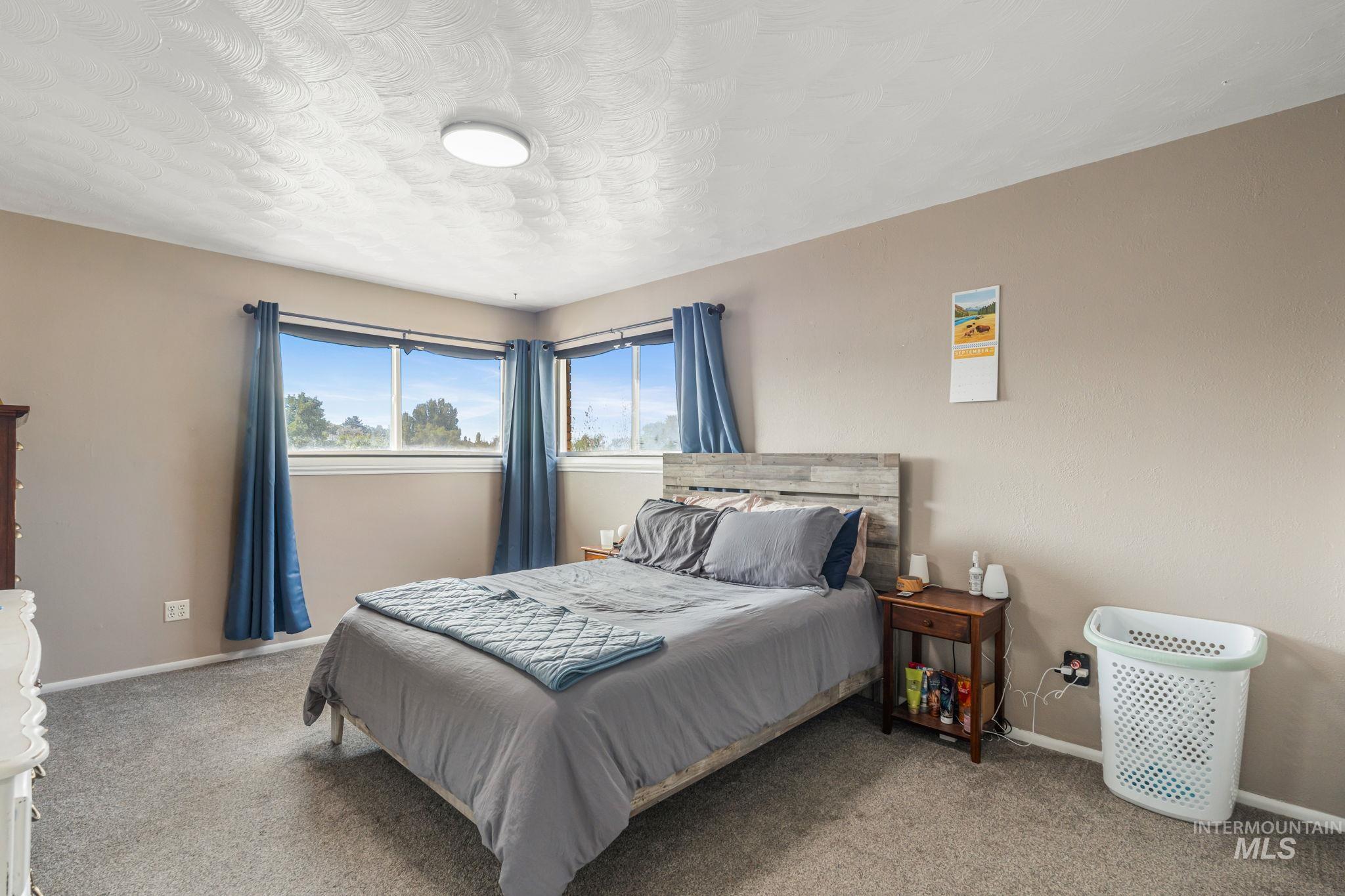 Carpeted bedroom with baseboards and a textured ceiling