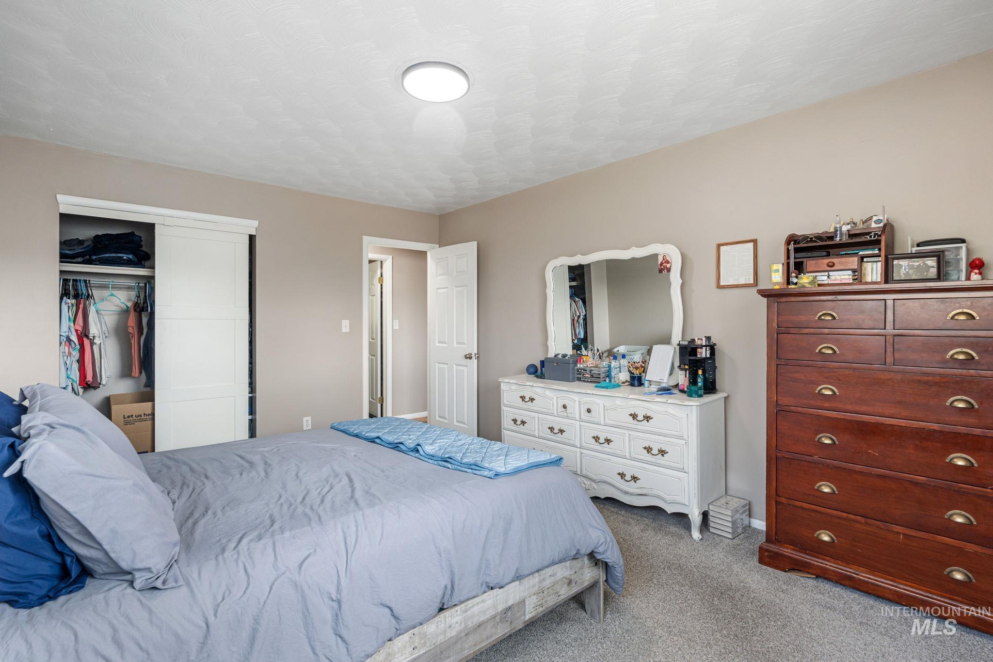Carpeted bedroom featuring a closet and a textured ceiling