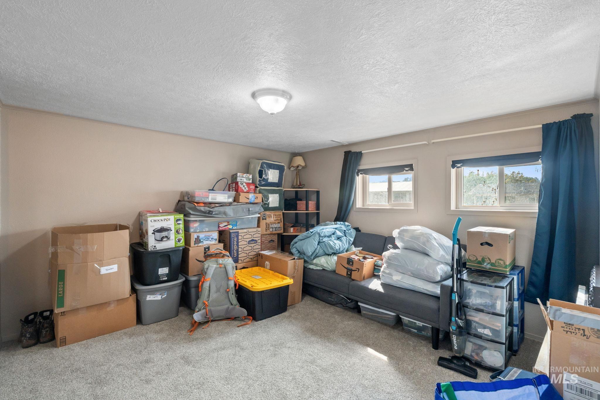Bedroom featuring carpet and a textured ceiling