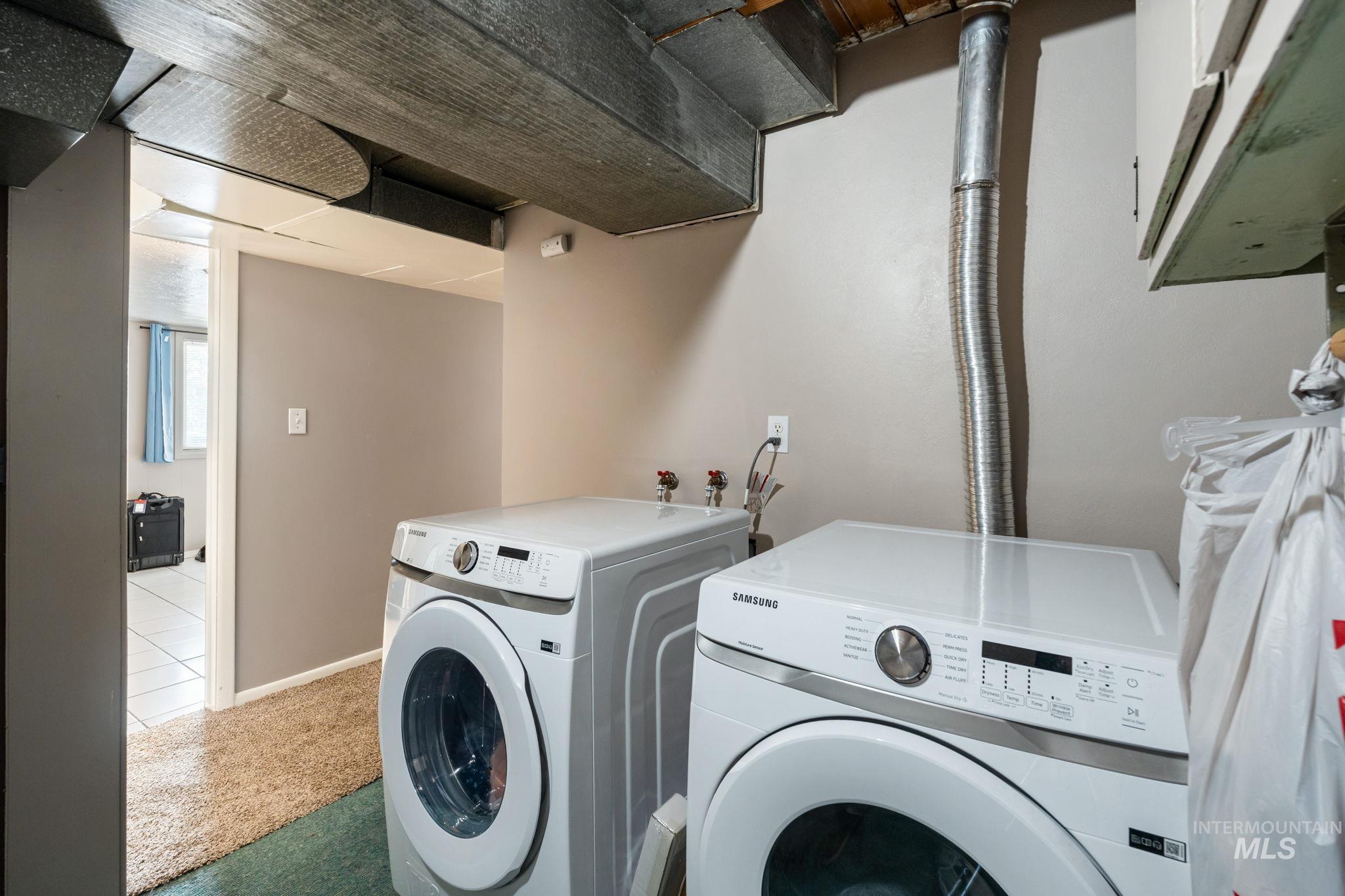 Washroom featuring washer and dryer and baseboards