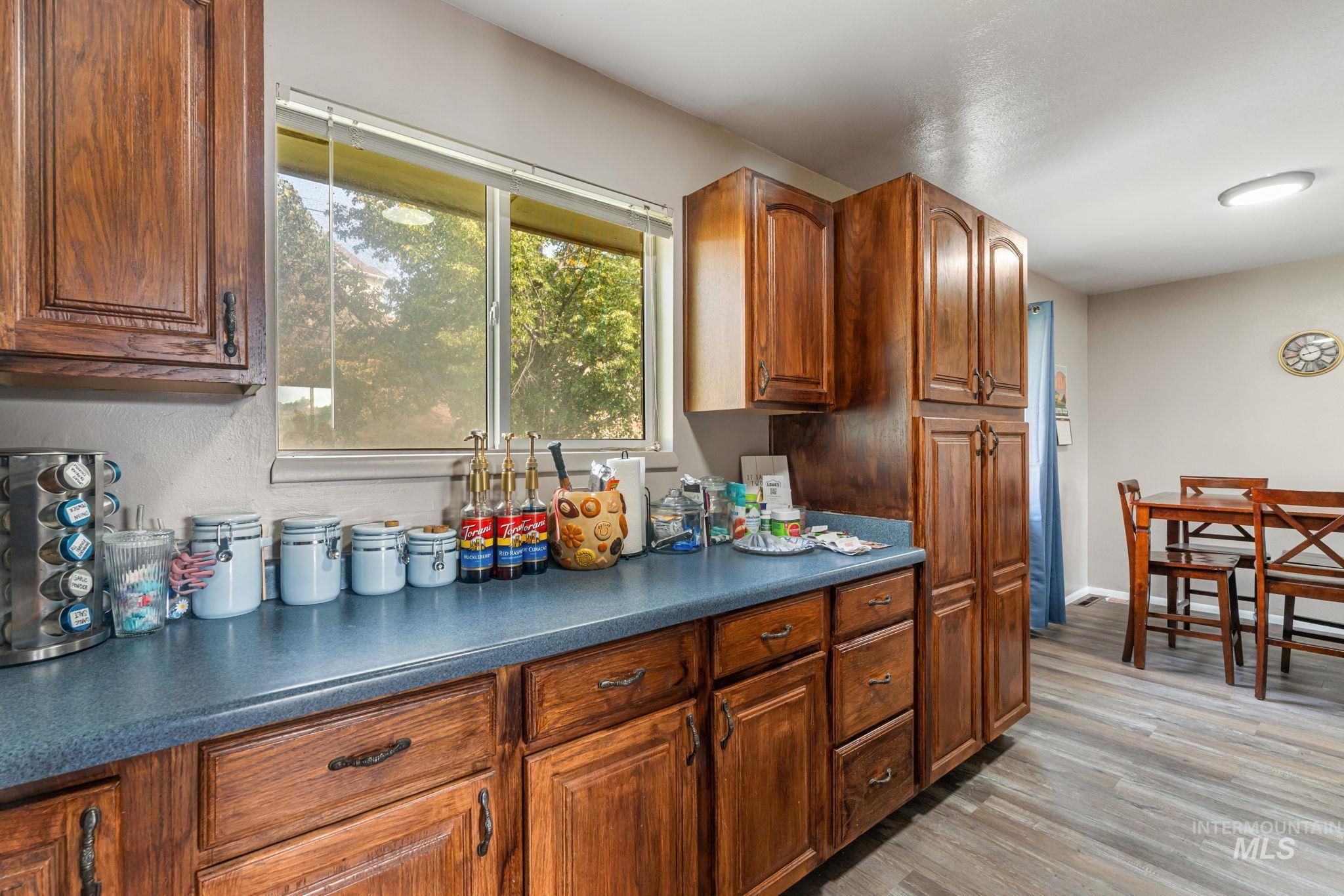 Kitchen with dark countertops, light wood-style flooring, and brown cabinetry