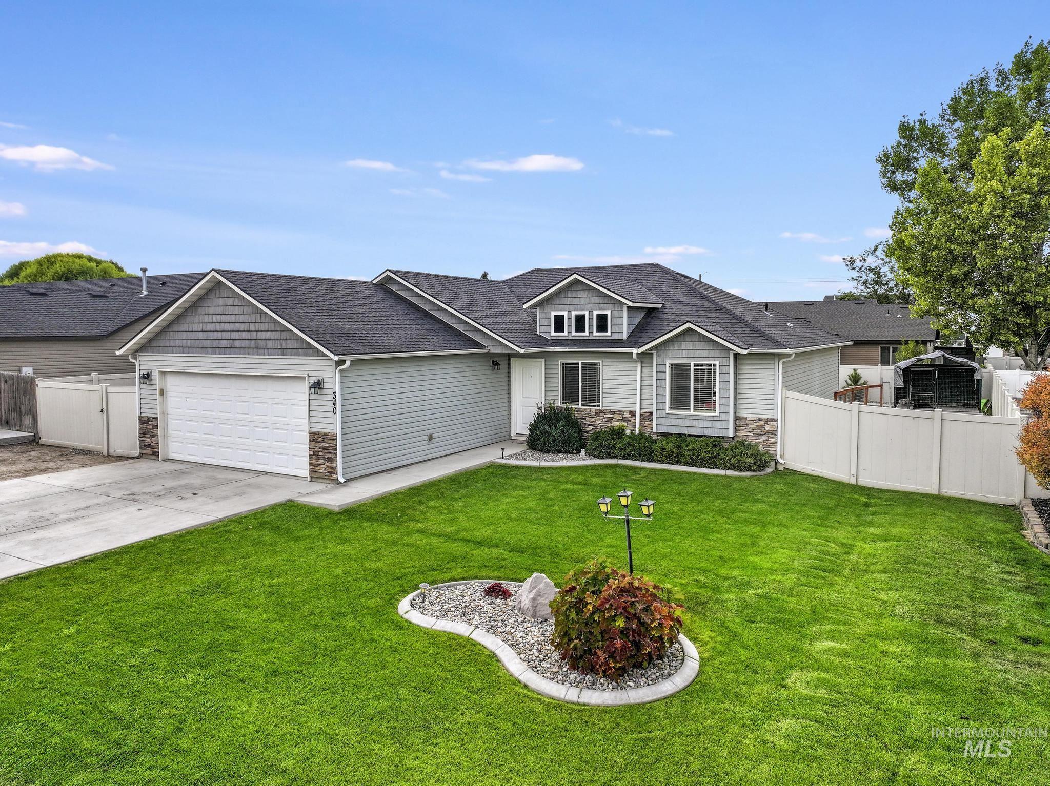 View of front of property with stone siding, roof with shingles, concrete driveway, and an attached garage