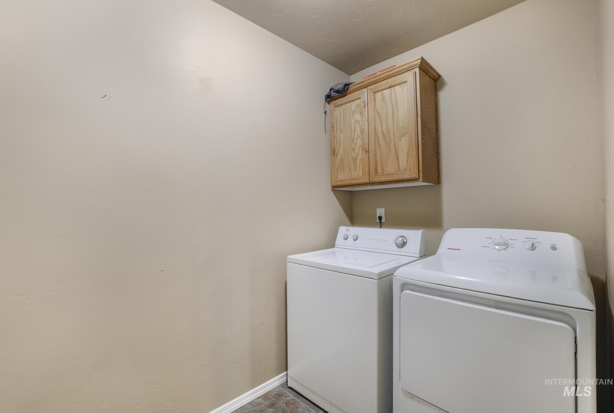 Washroom featuring cabinet space and washer and clothes dryer