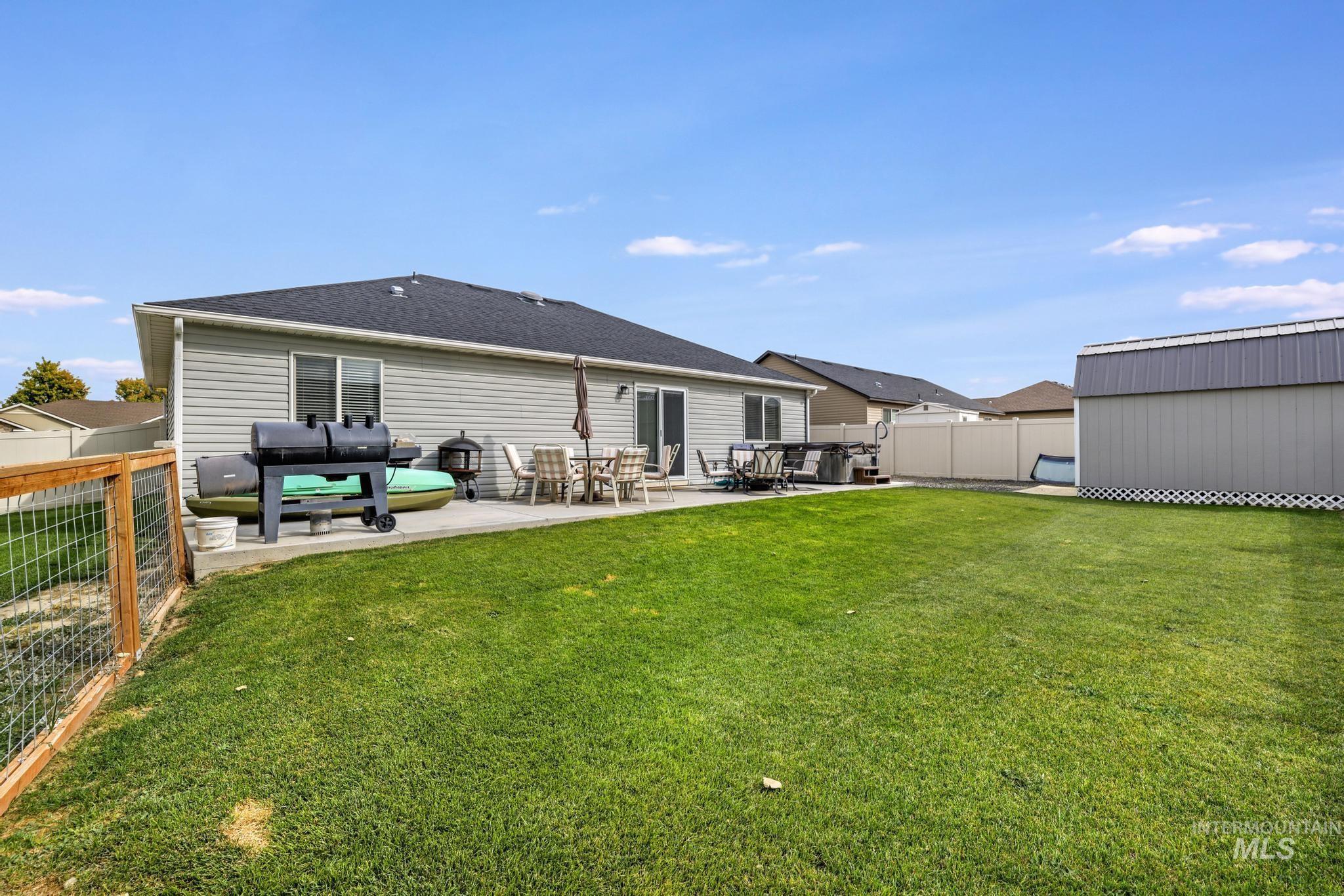 Back of house with a patio, a fenced backyard, and roof with shingles
