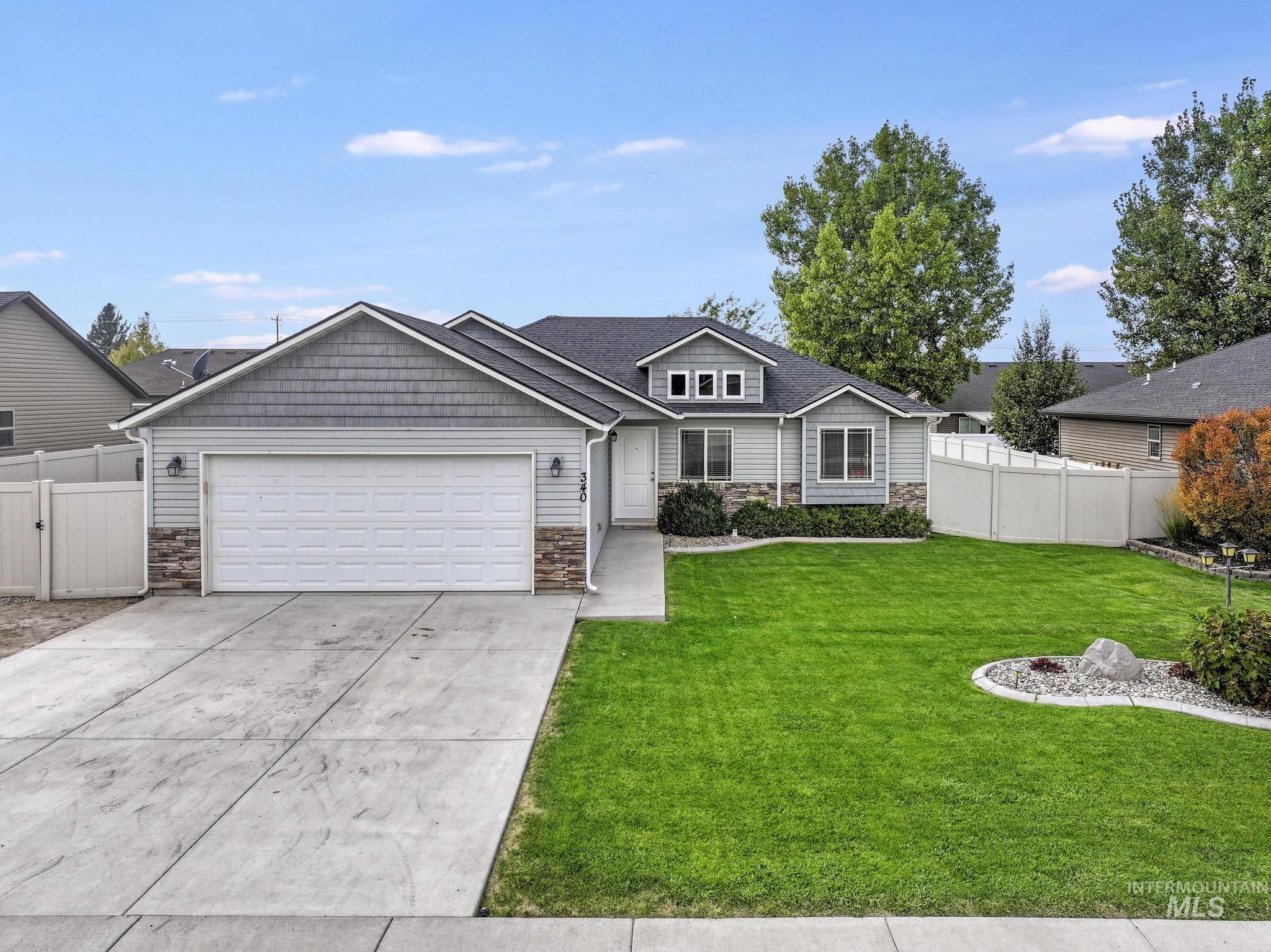 View of front of home featuring stone siding, concrete driveway, and an attached garage