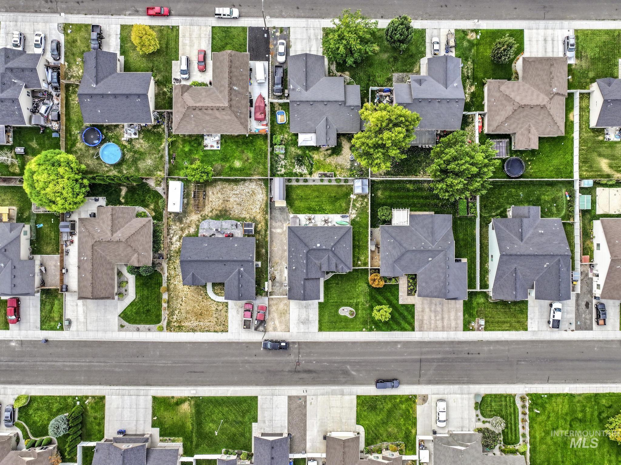 Aerial view of property and surrounding area featuring nearby suburban area