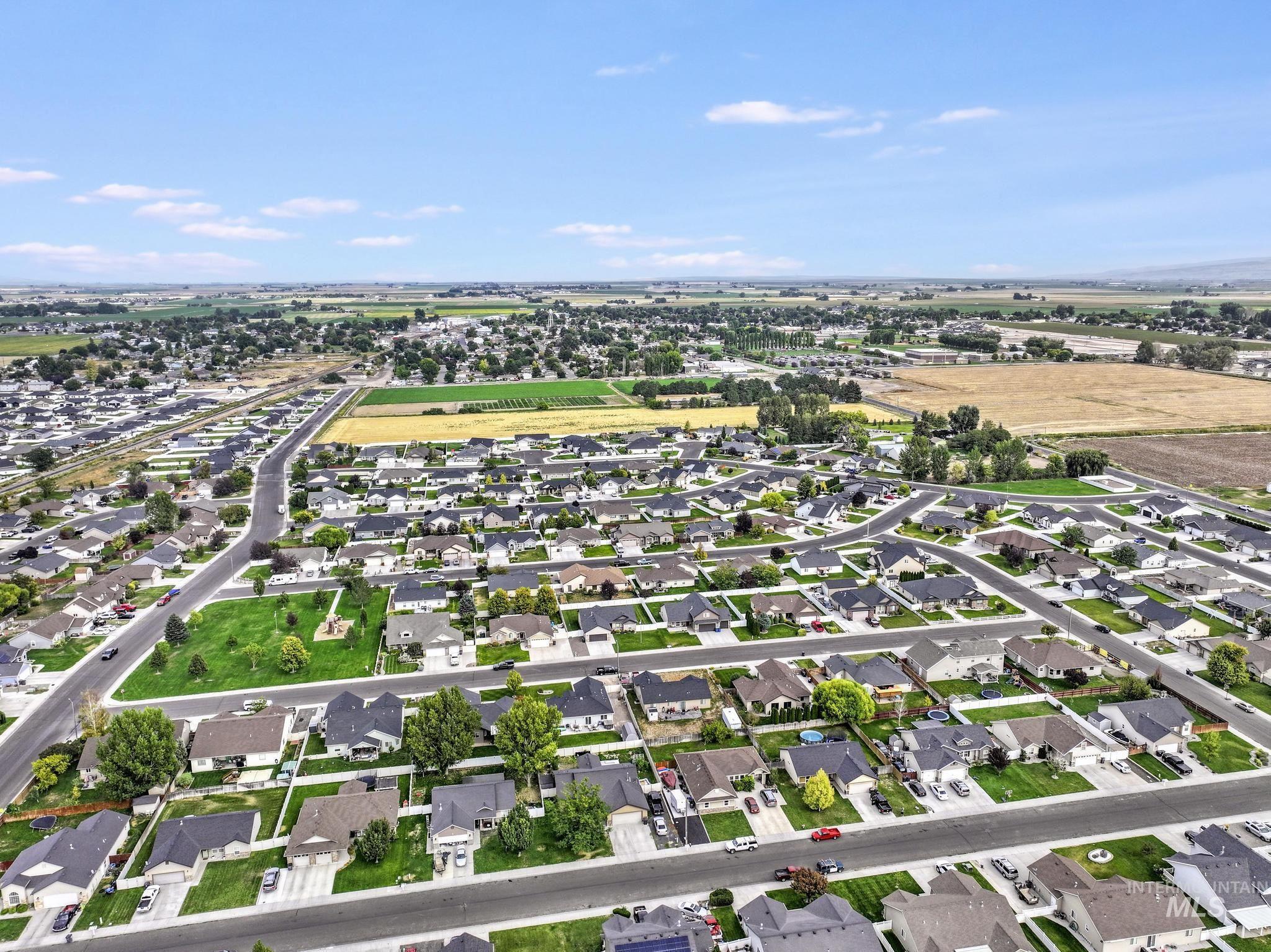 Aerial view of property and surrounding area featuring nearby suburban area