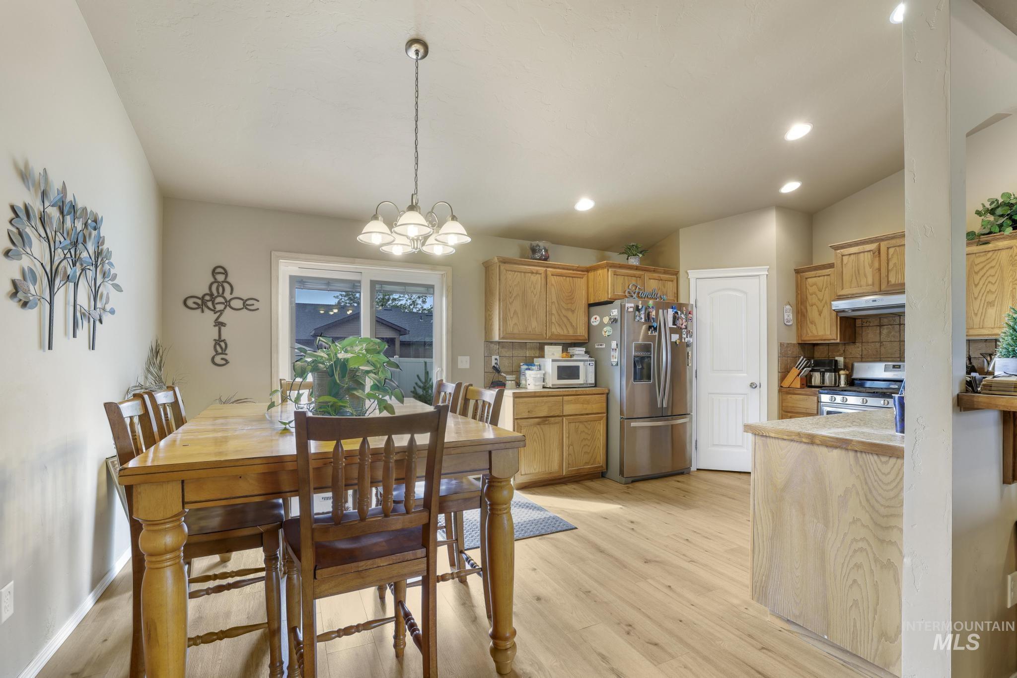 Dining area with light wood-style flooring, a chandelier, and recessed lighting
