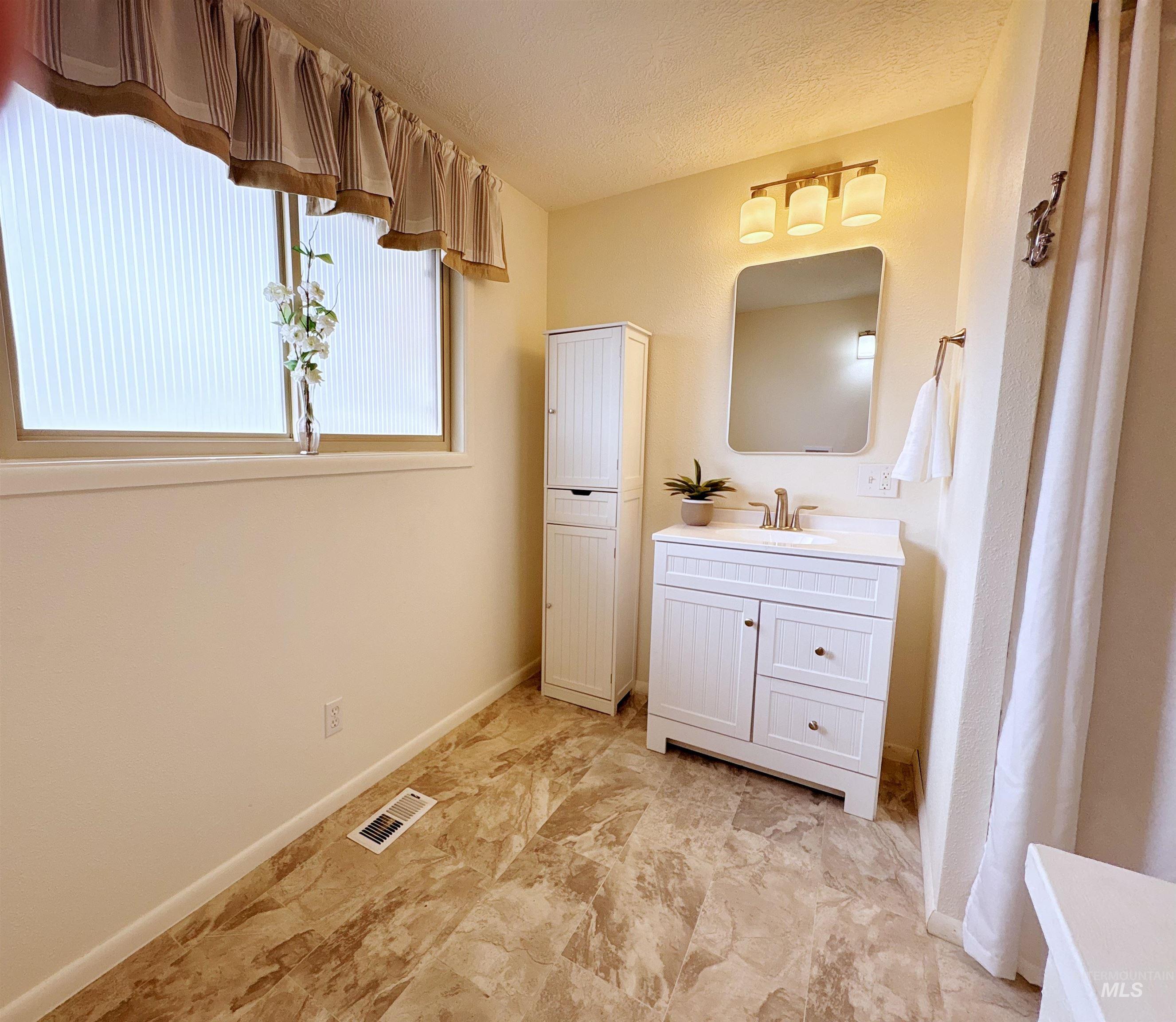 Bathroom with vanity and a textured ceiling