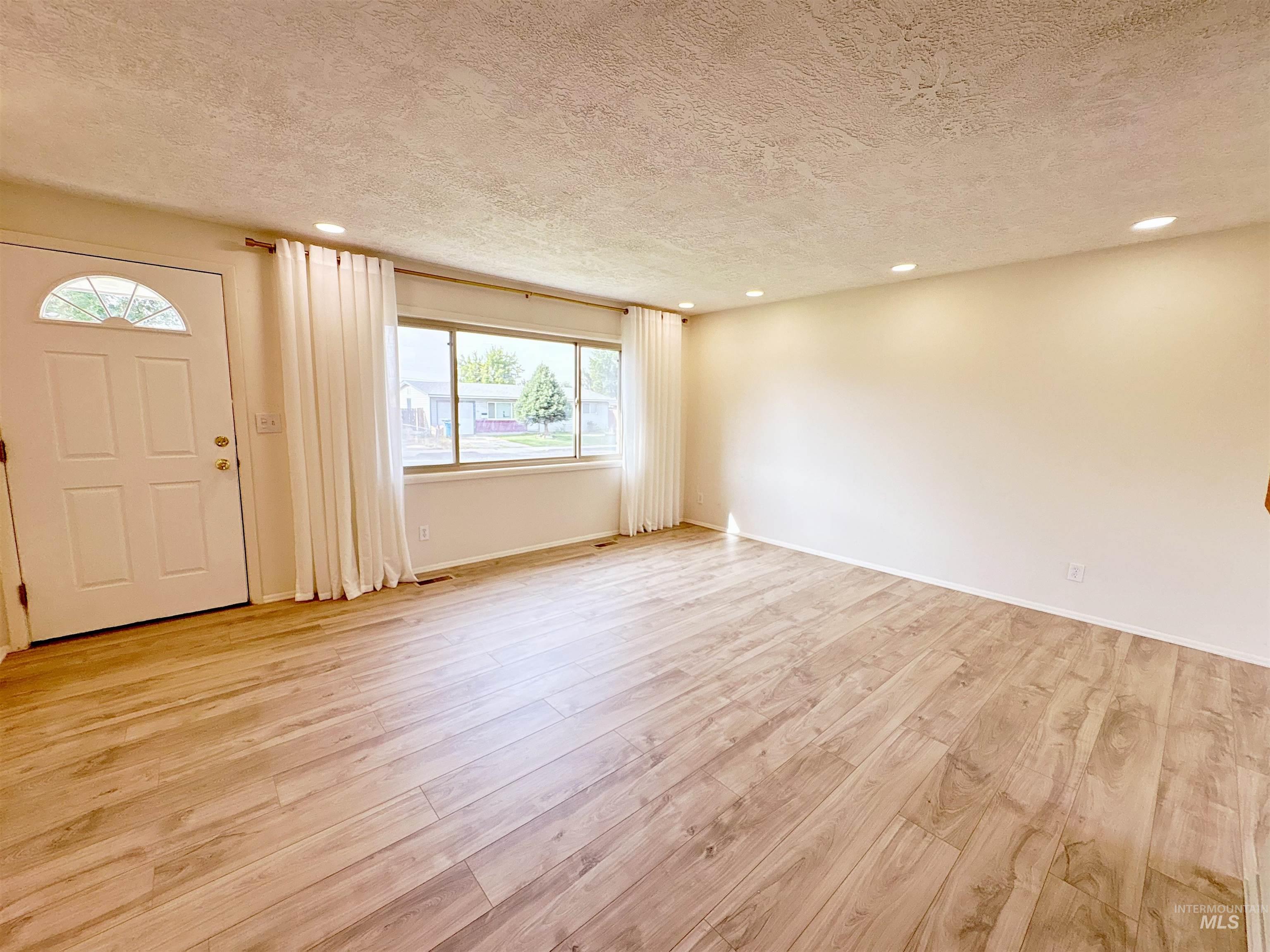 Foyer entrance featuring recessed lighting, a textured ceiling, and light wood-style floors