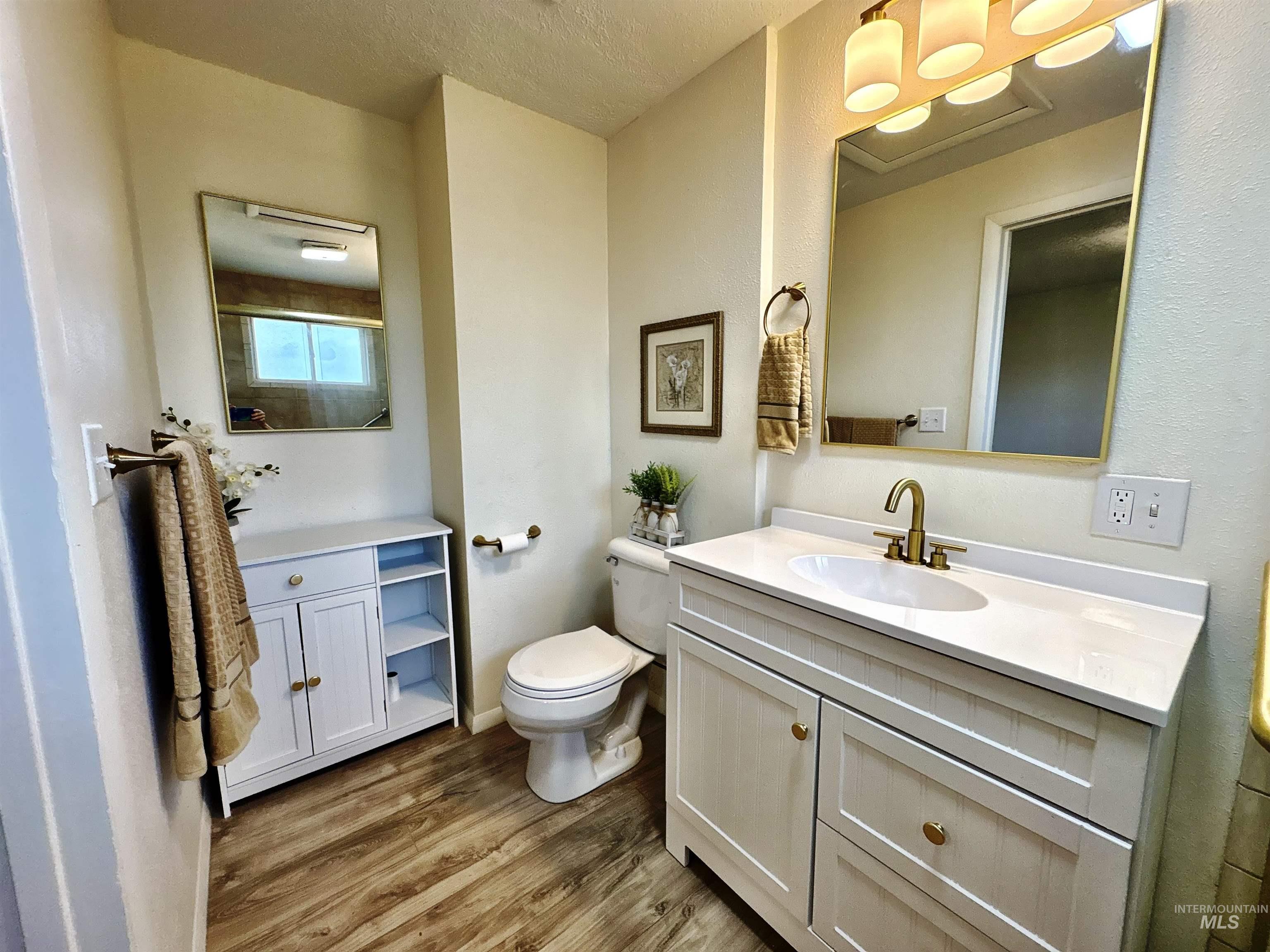 Bathroom with light wood-type flooring, vanity, and a shower