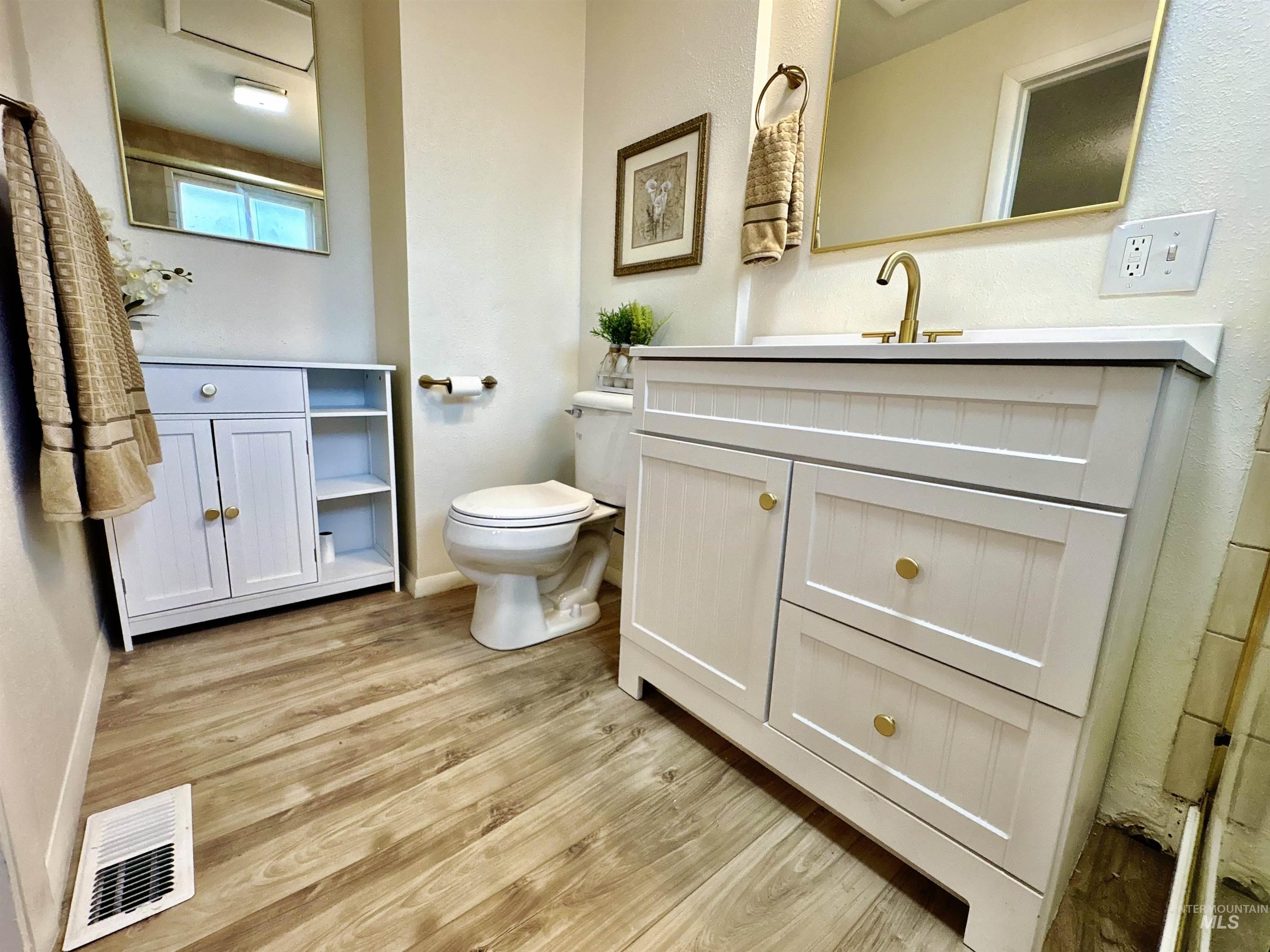 Full bathroom with light wood finished floors and vanity