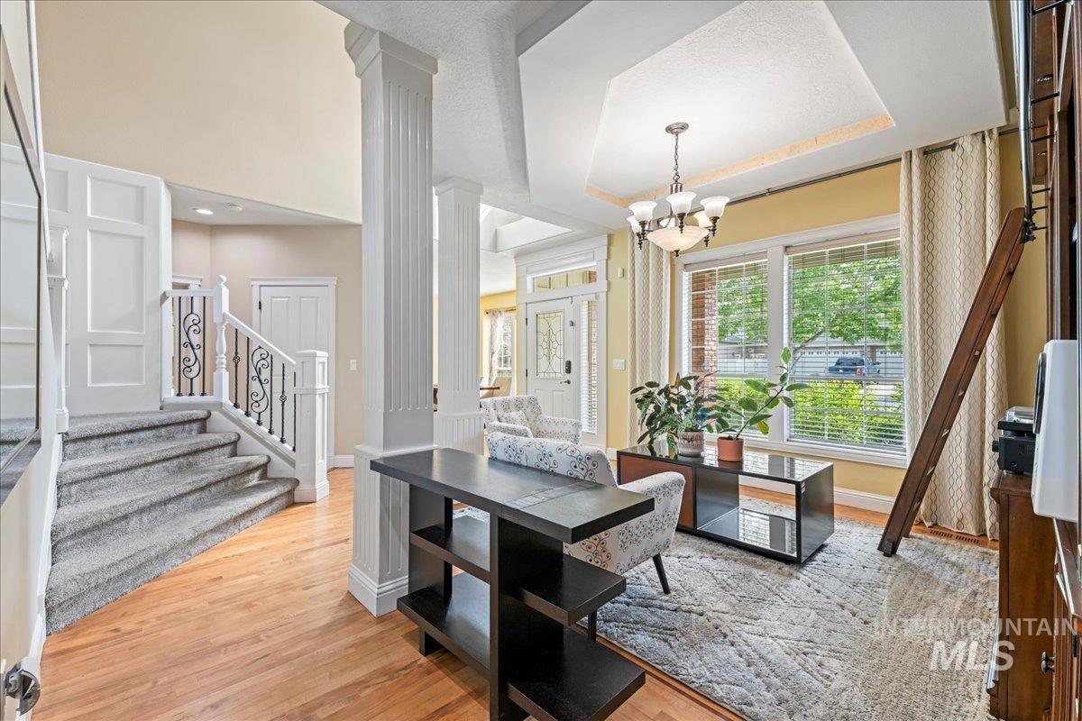 Dining space featuring a raised ceiling, plenty of natural light, and light wood-style flooring