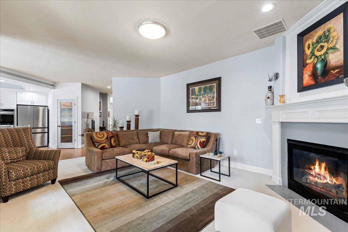 Living area featuring recessed lighting, a tiled fireplace, and a textured ceiling