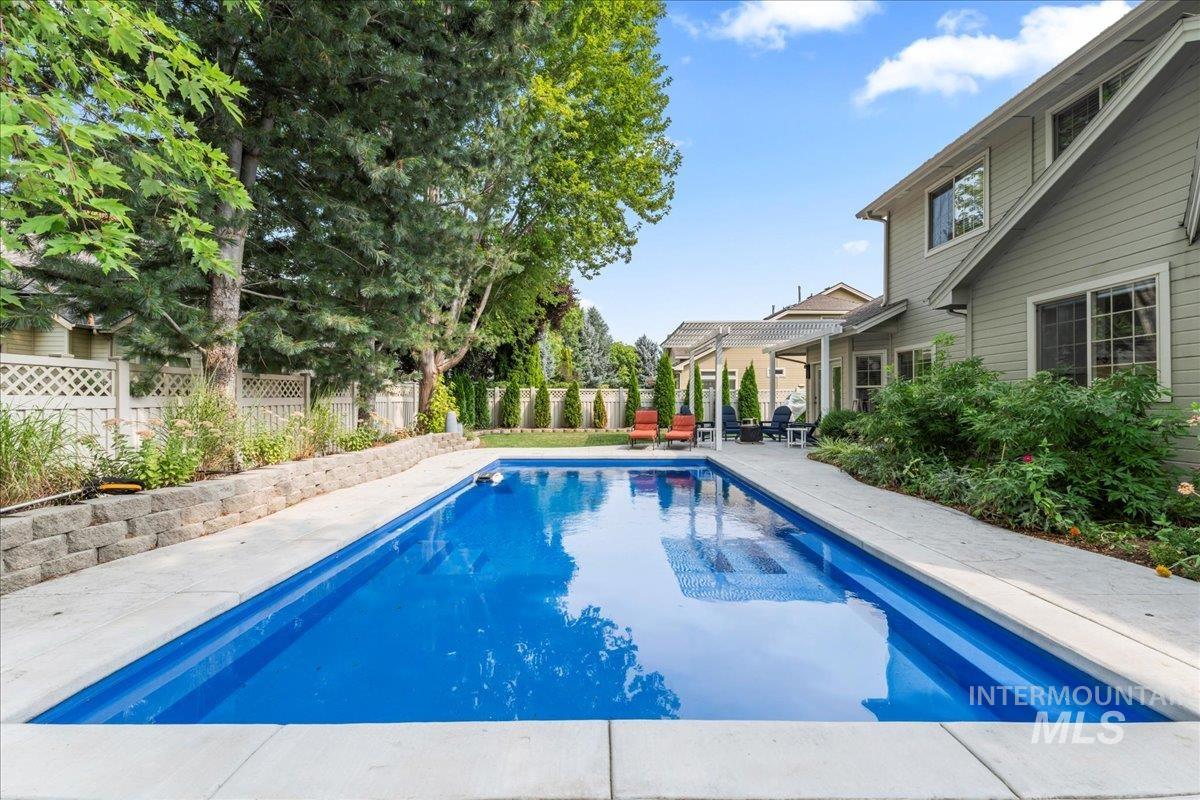 View of swimming pool with a patio and a fenced backyard
