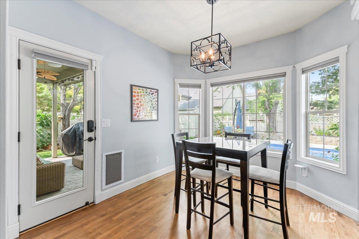 Dining room with plenty of natural light, light wood-type flooring, and a chandelier