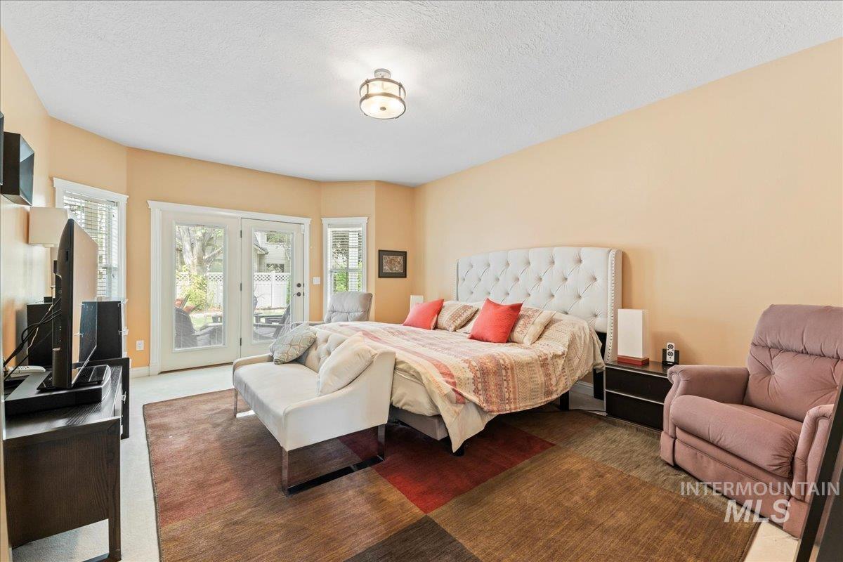 Bedroom featuring carpet flooring, access to outside, and a textured ceiling