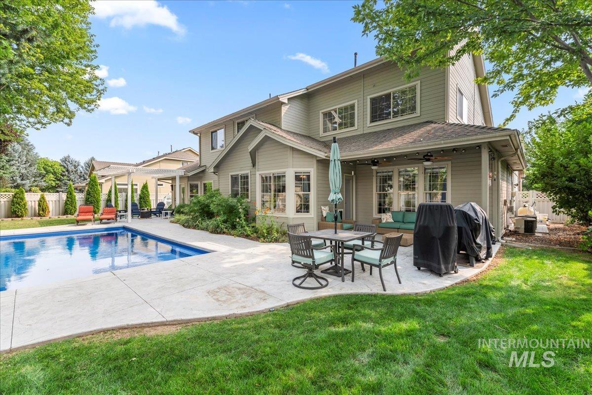 Rear view of property with a patio area, a shingled roof, and a ceiling fan