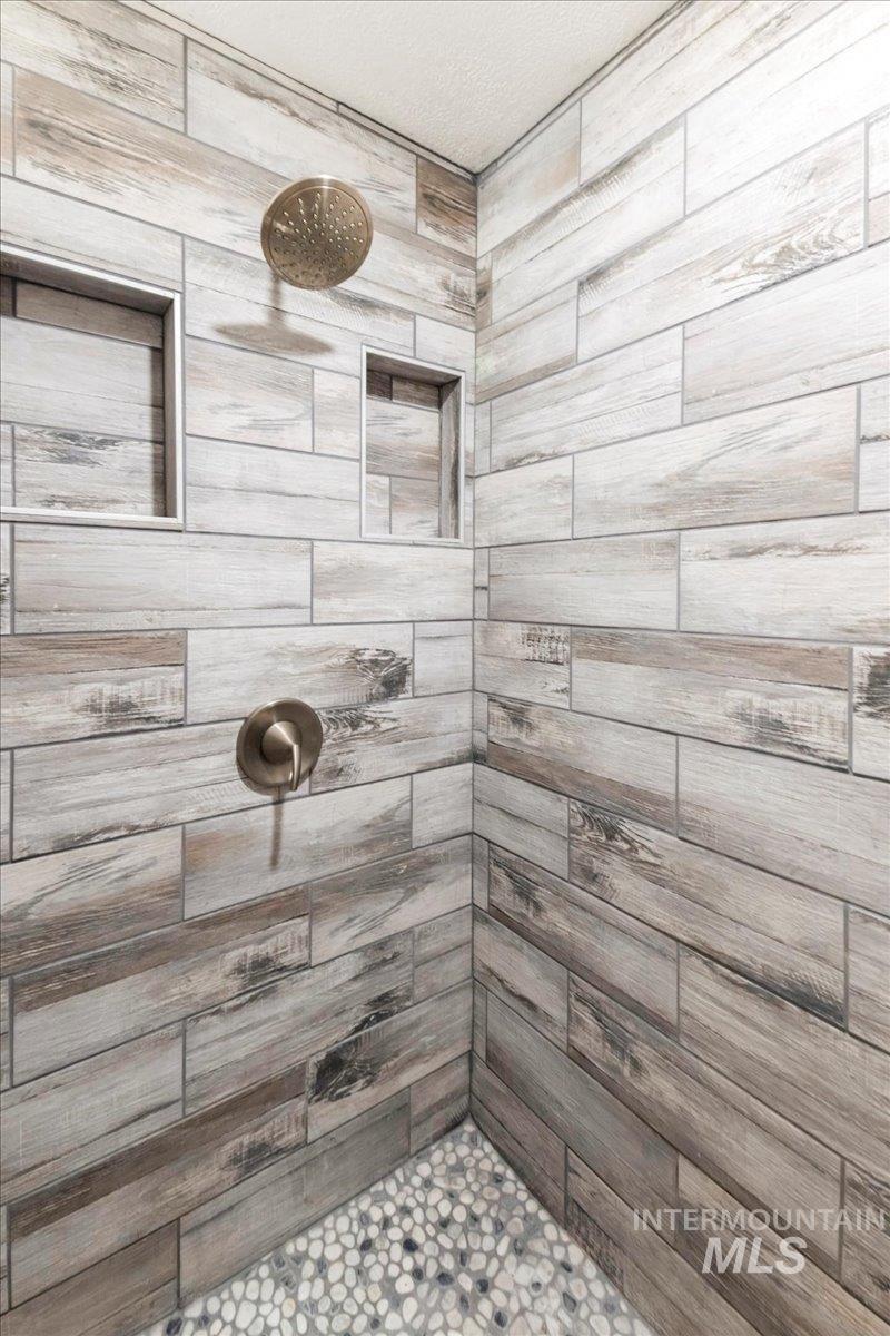 Bathroom with a tile shower and a textured ceiling