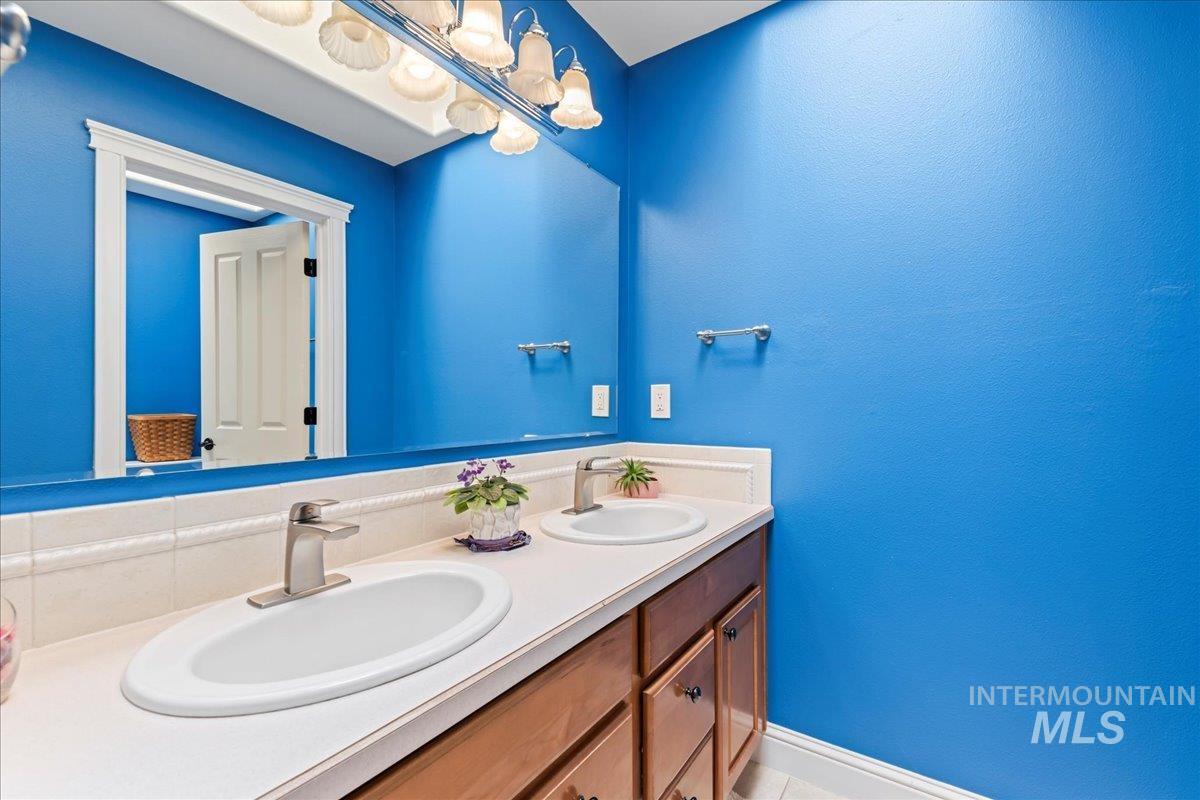 Bathroom featuring double vanity and light tile patterned flooring